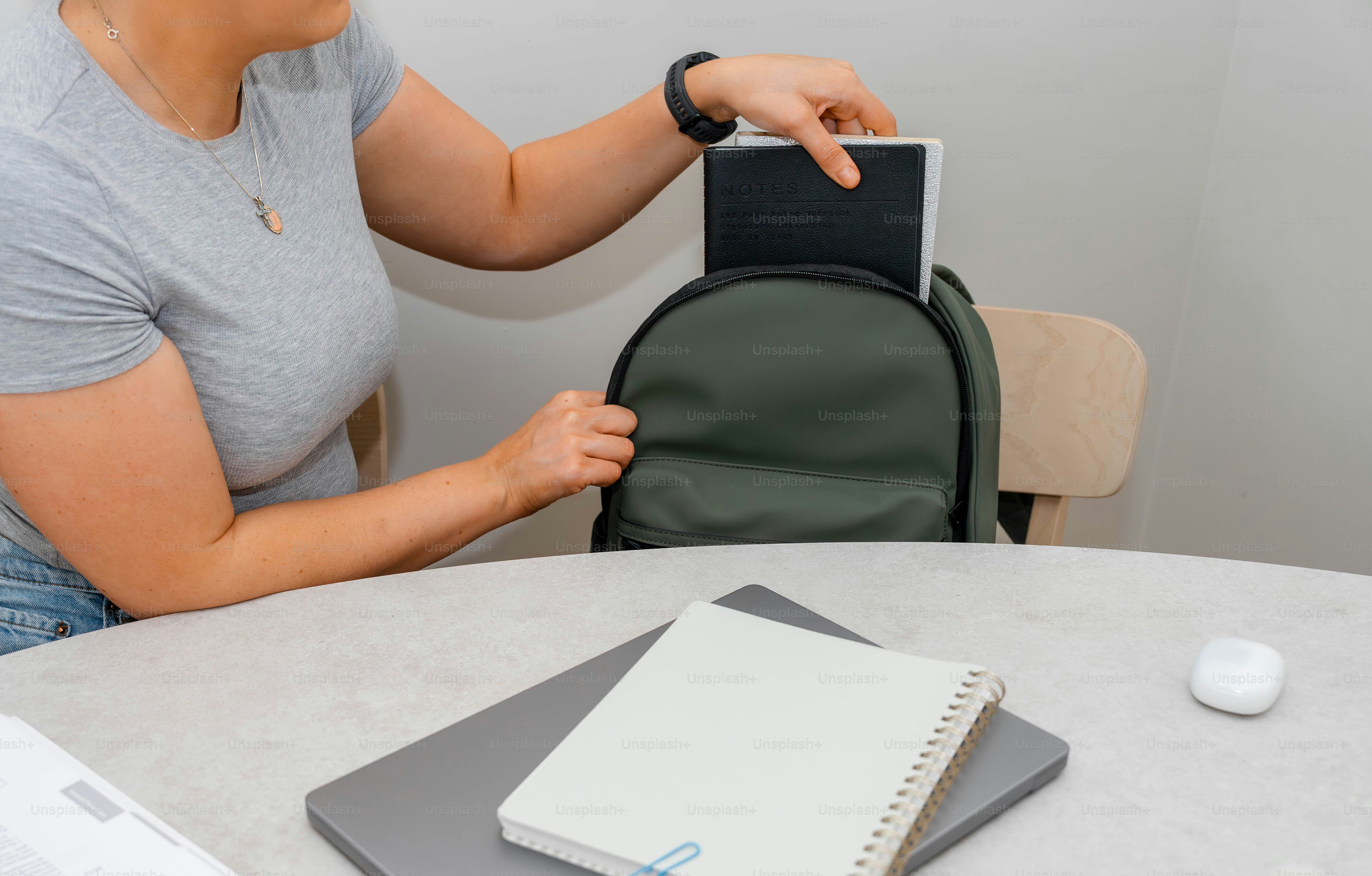 A woman sitting at a table with a backpack