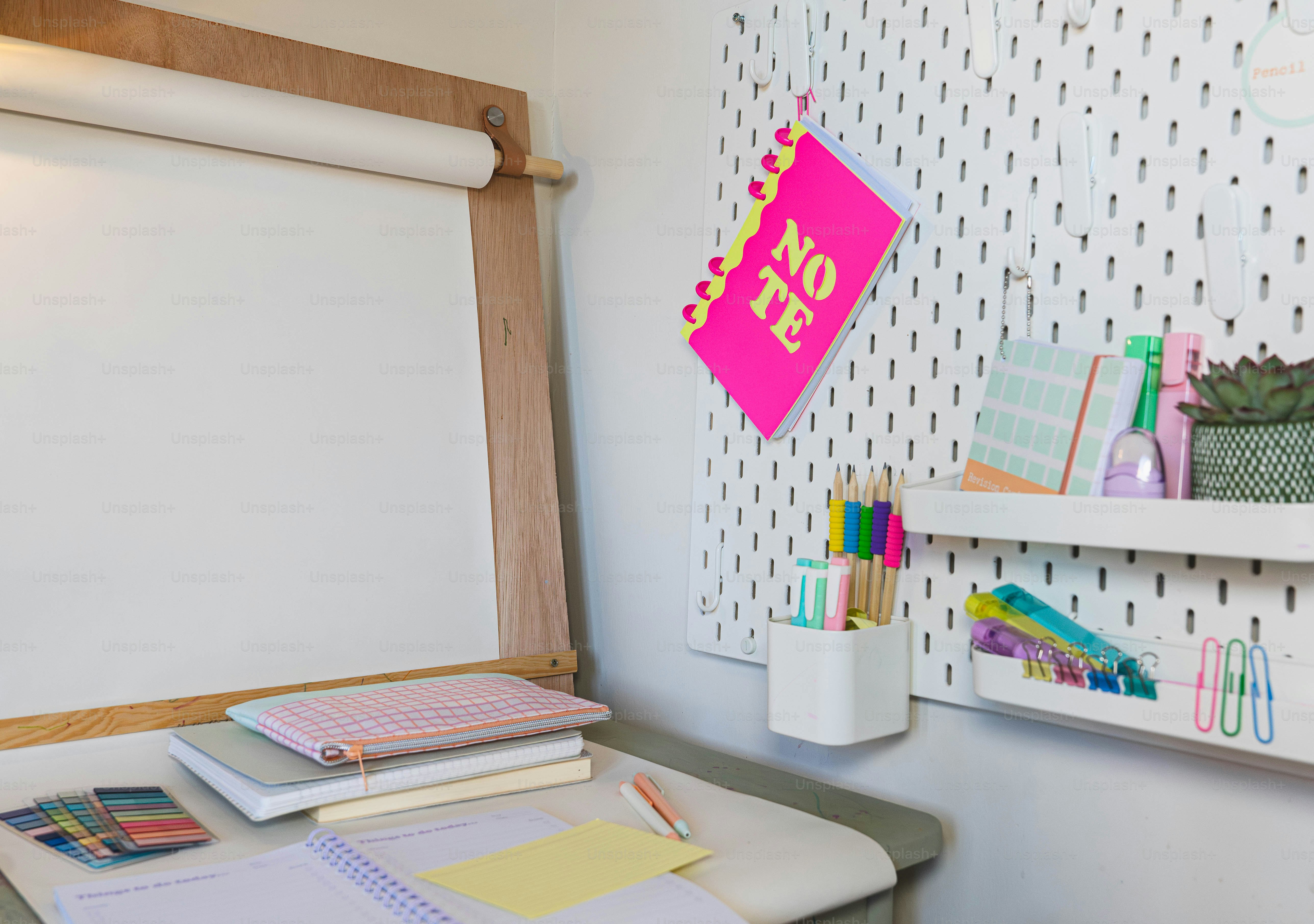 A desk with a whiteboard and a shelf with pens and paper