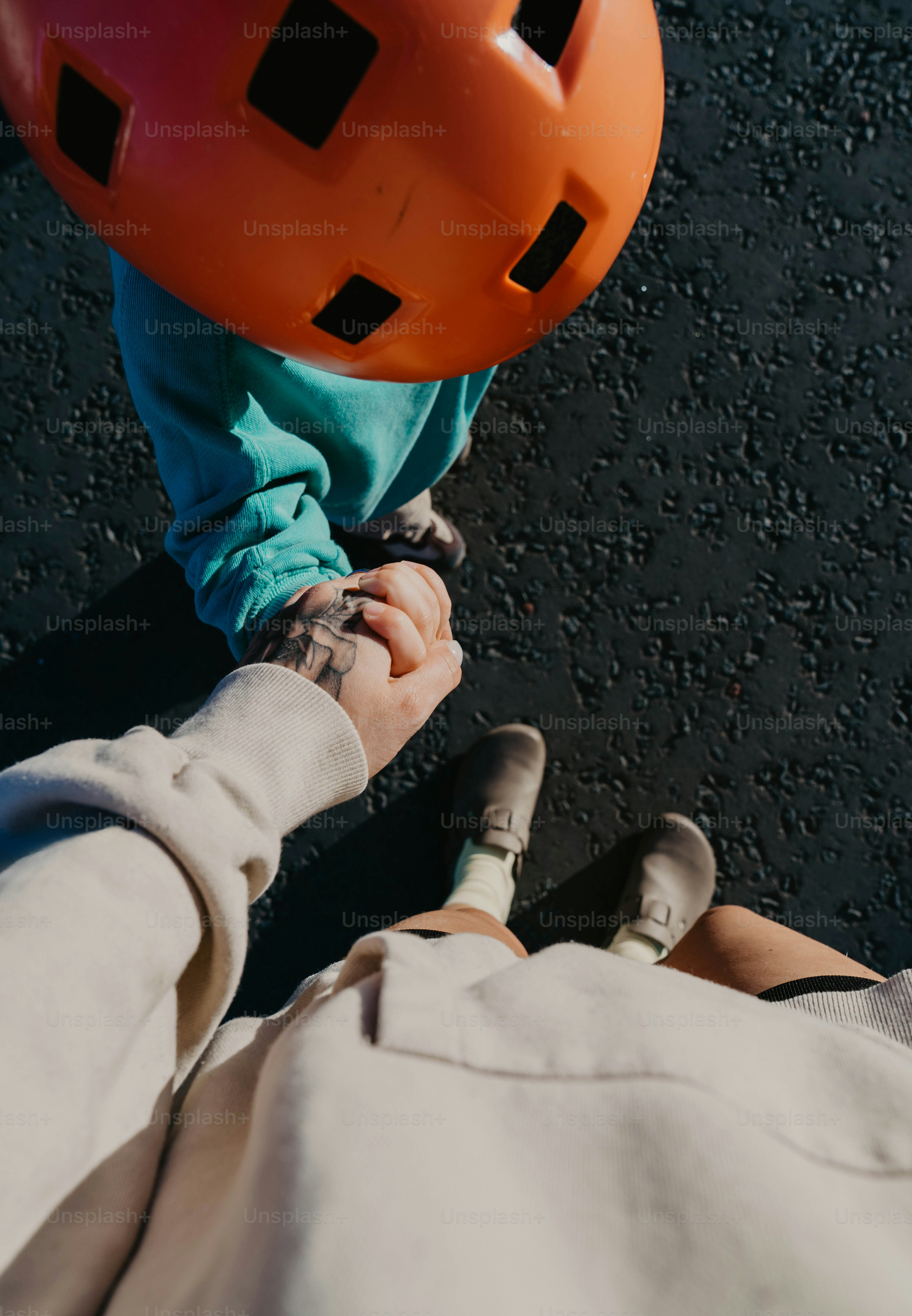 A person holding the hand of another person wearing a helmet
