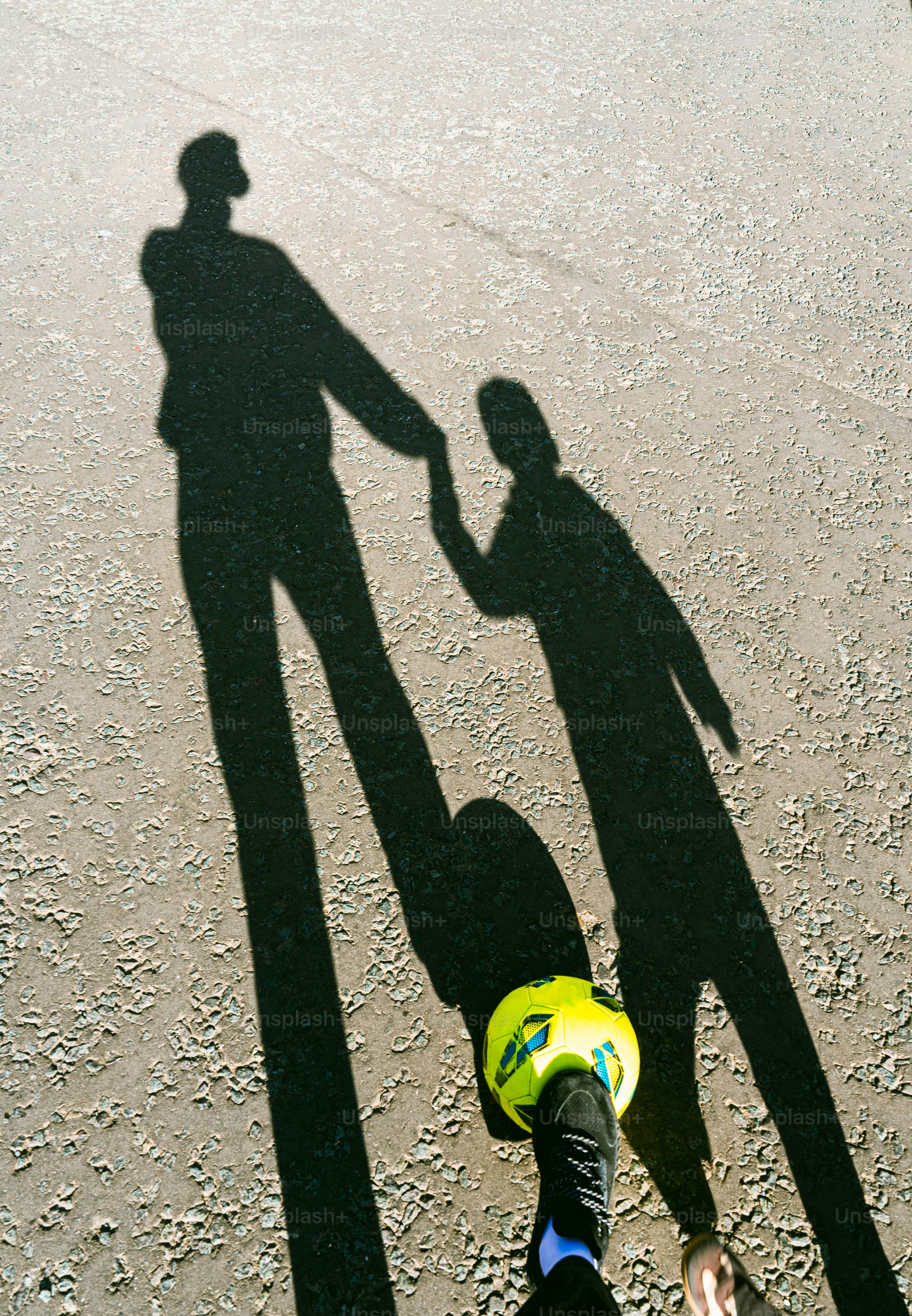A shadow of a man and a child holding hands