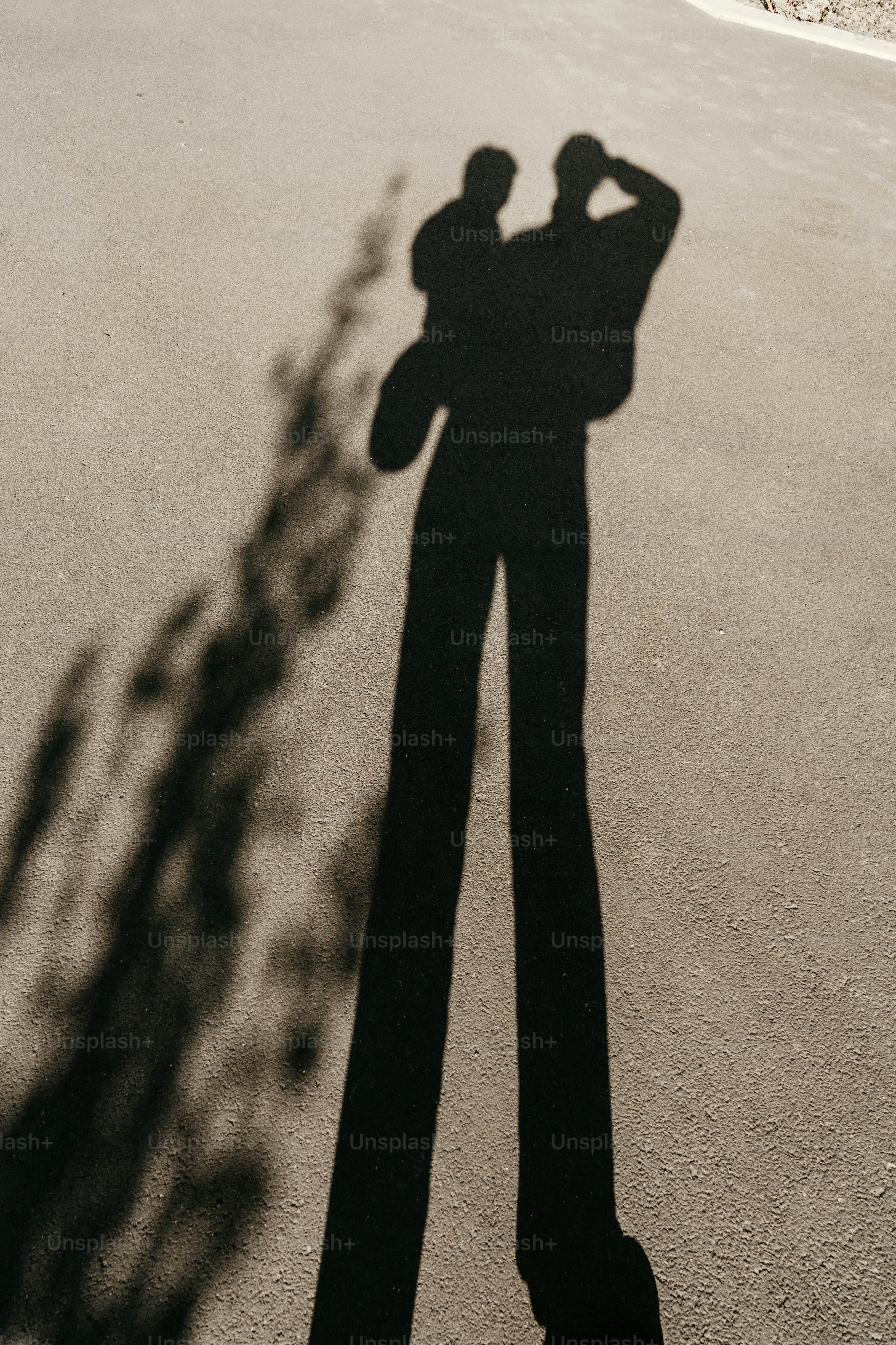 A shadow of a man standing in the middle of a street