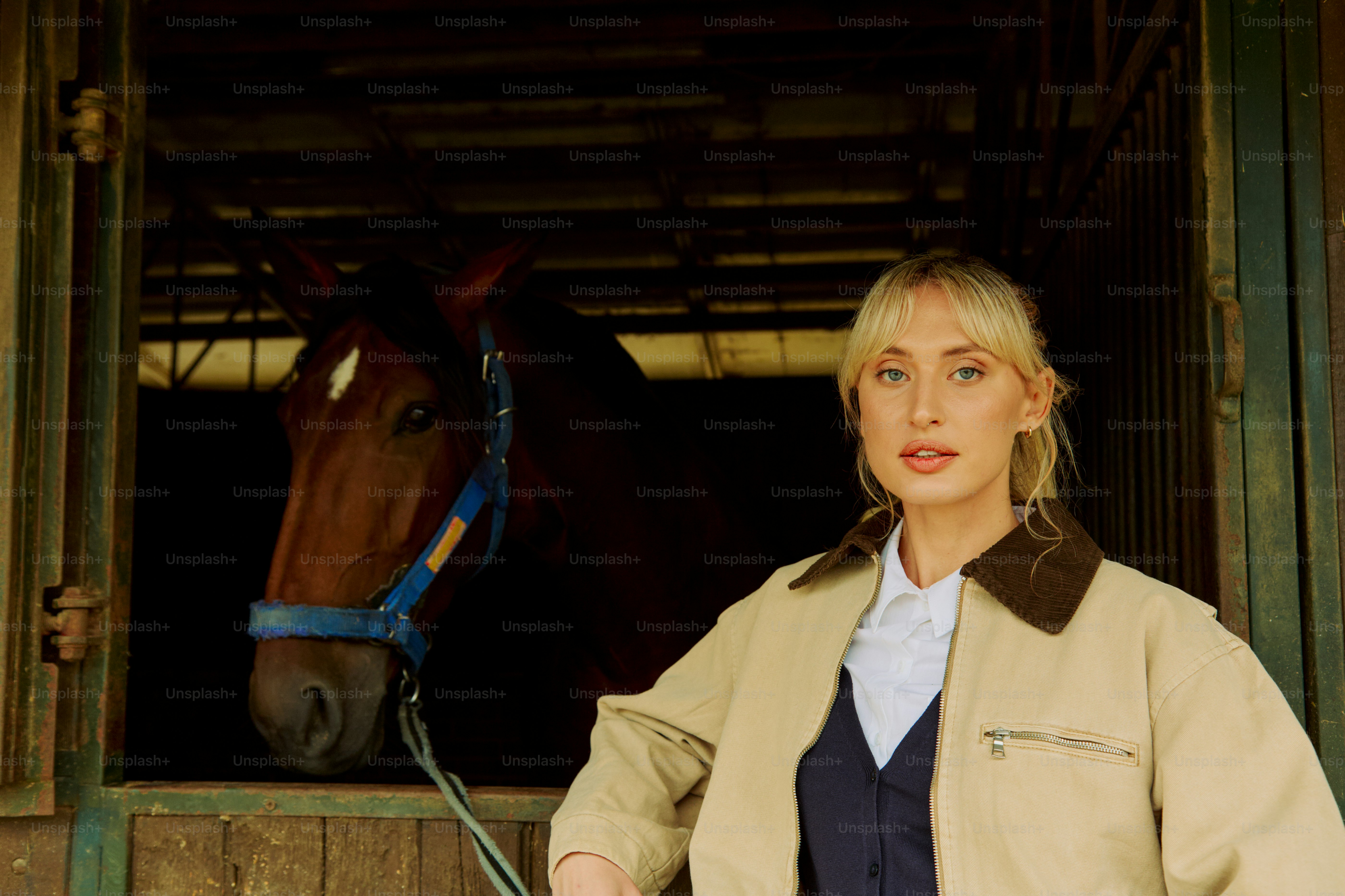A woman standing next to a horse in a stable