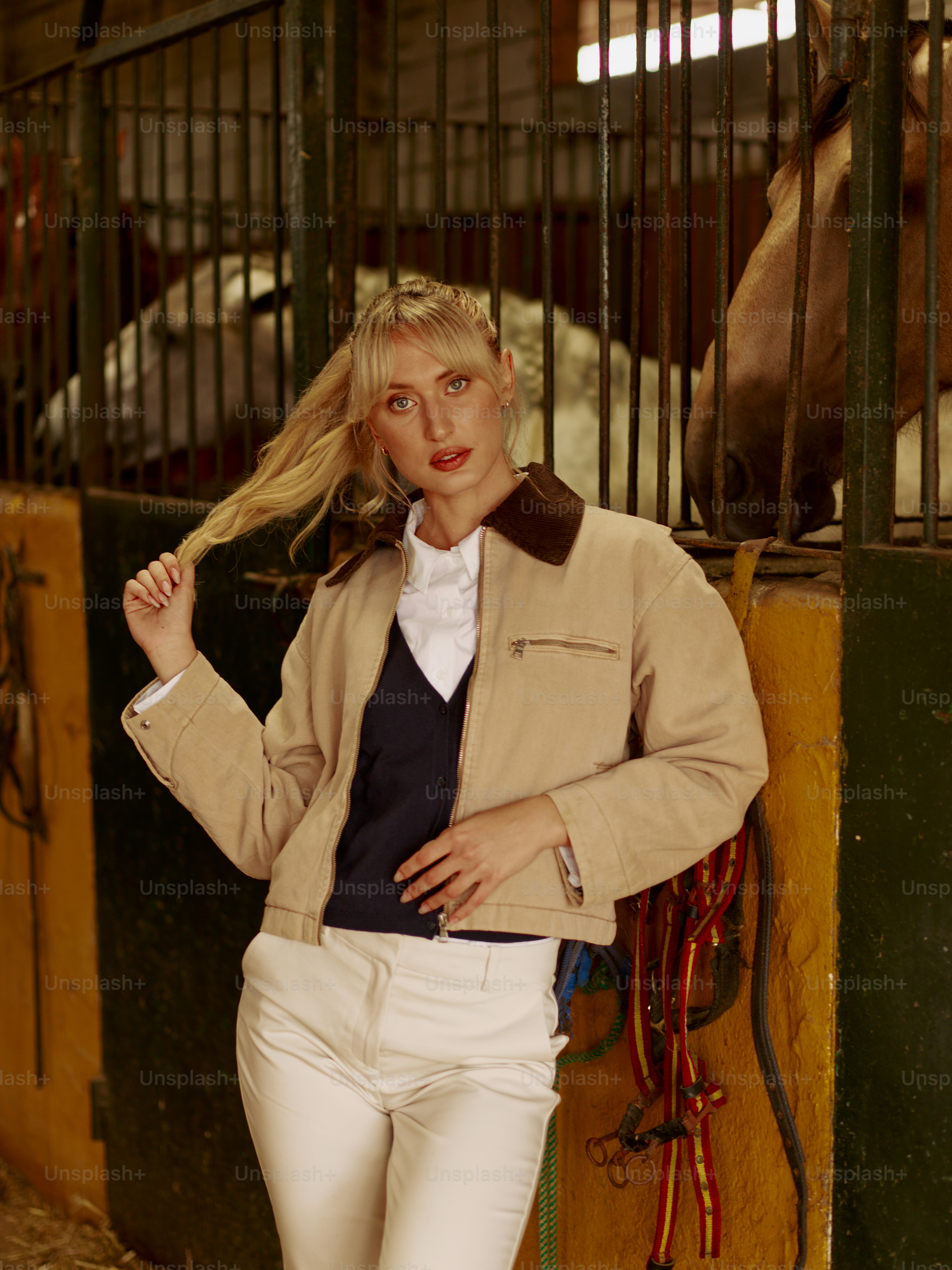 A woman standing next to a horse in a stable