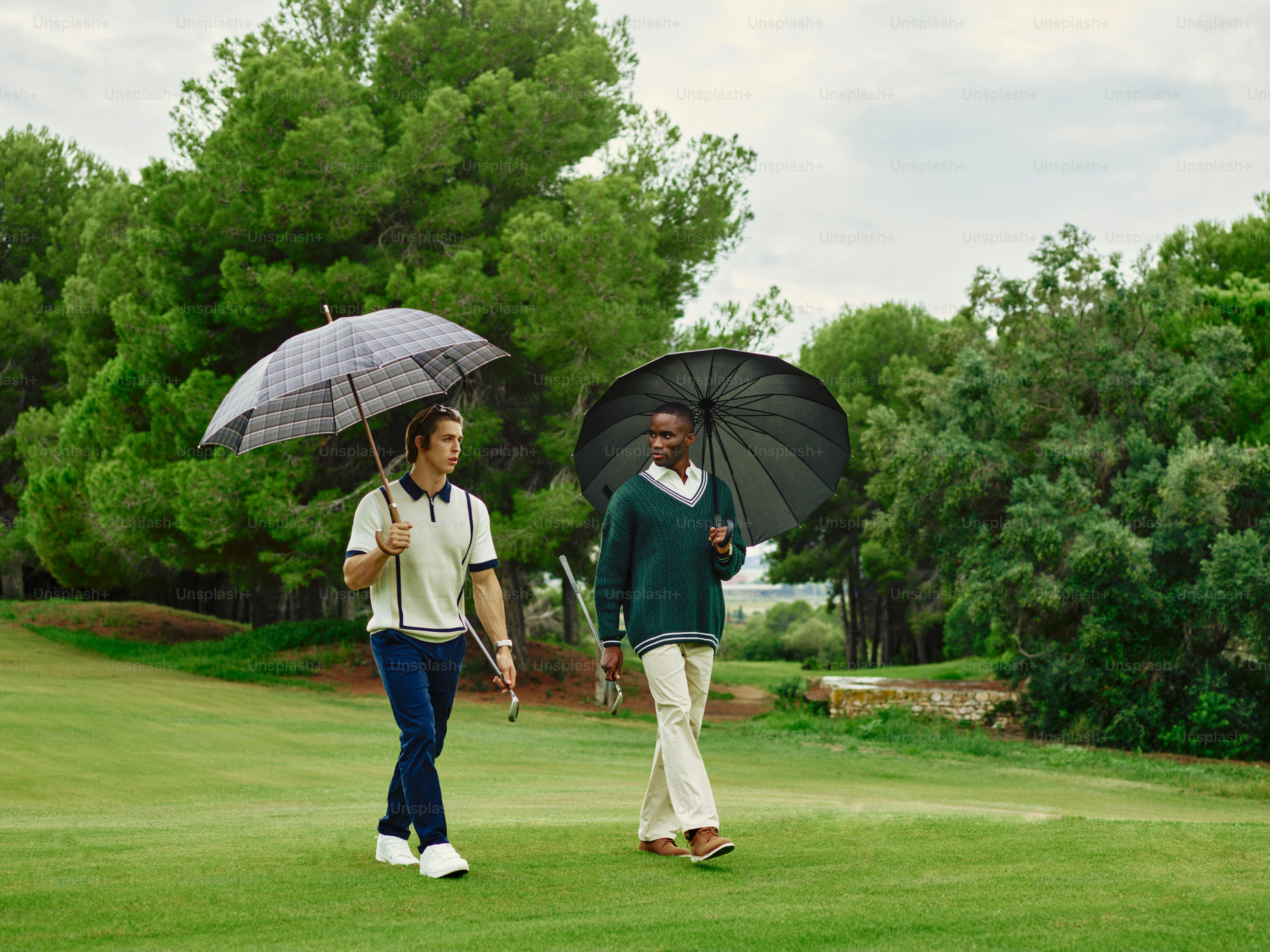 A couple of people walking across a lush green field