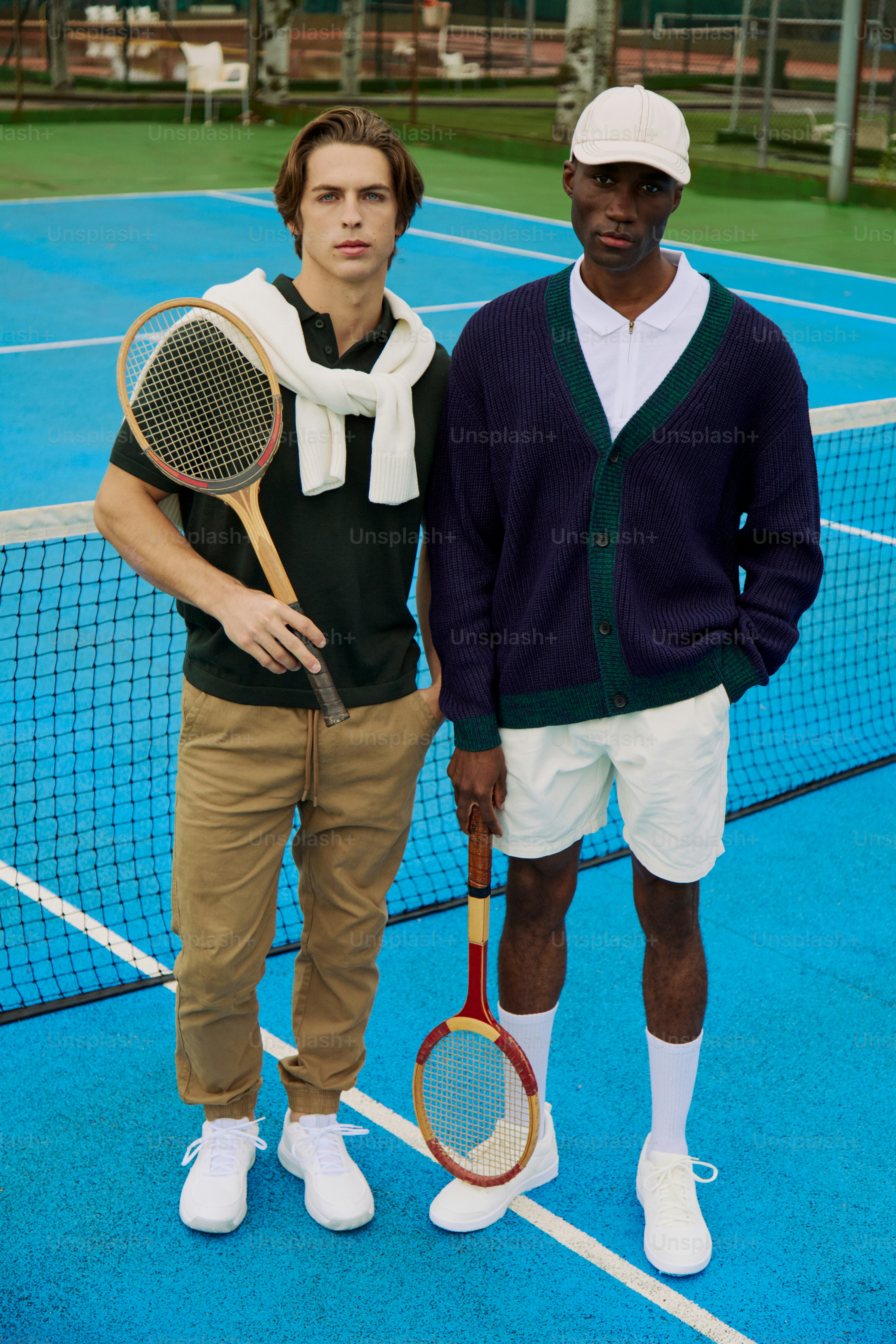 Two men standing on a tennis court holding racquets