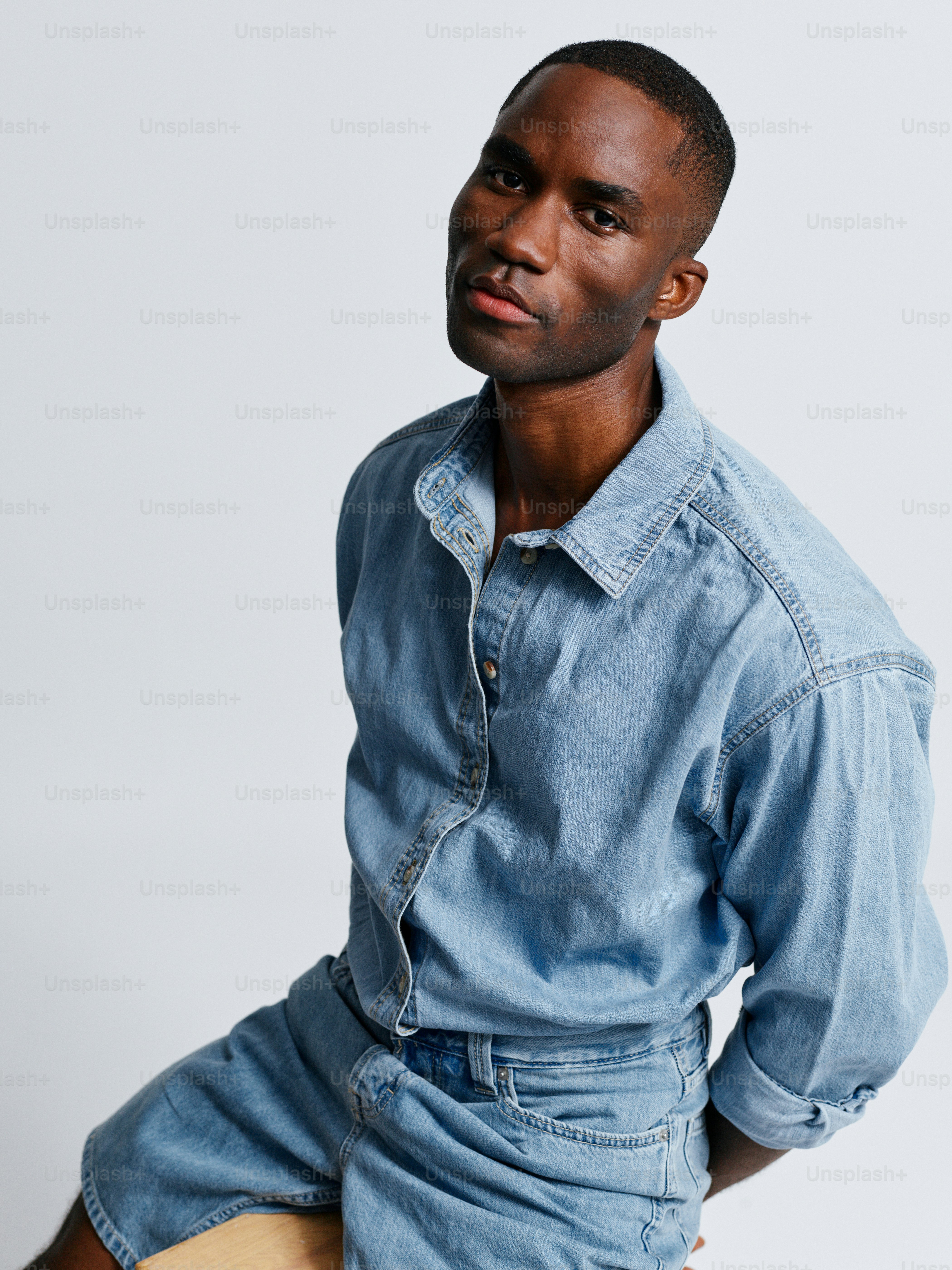 Un Uomo In Camicia Di Jeans E Pantaloncini Posa Per Una Foto Foto