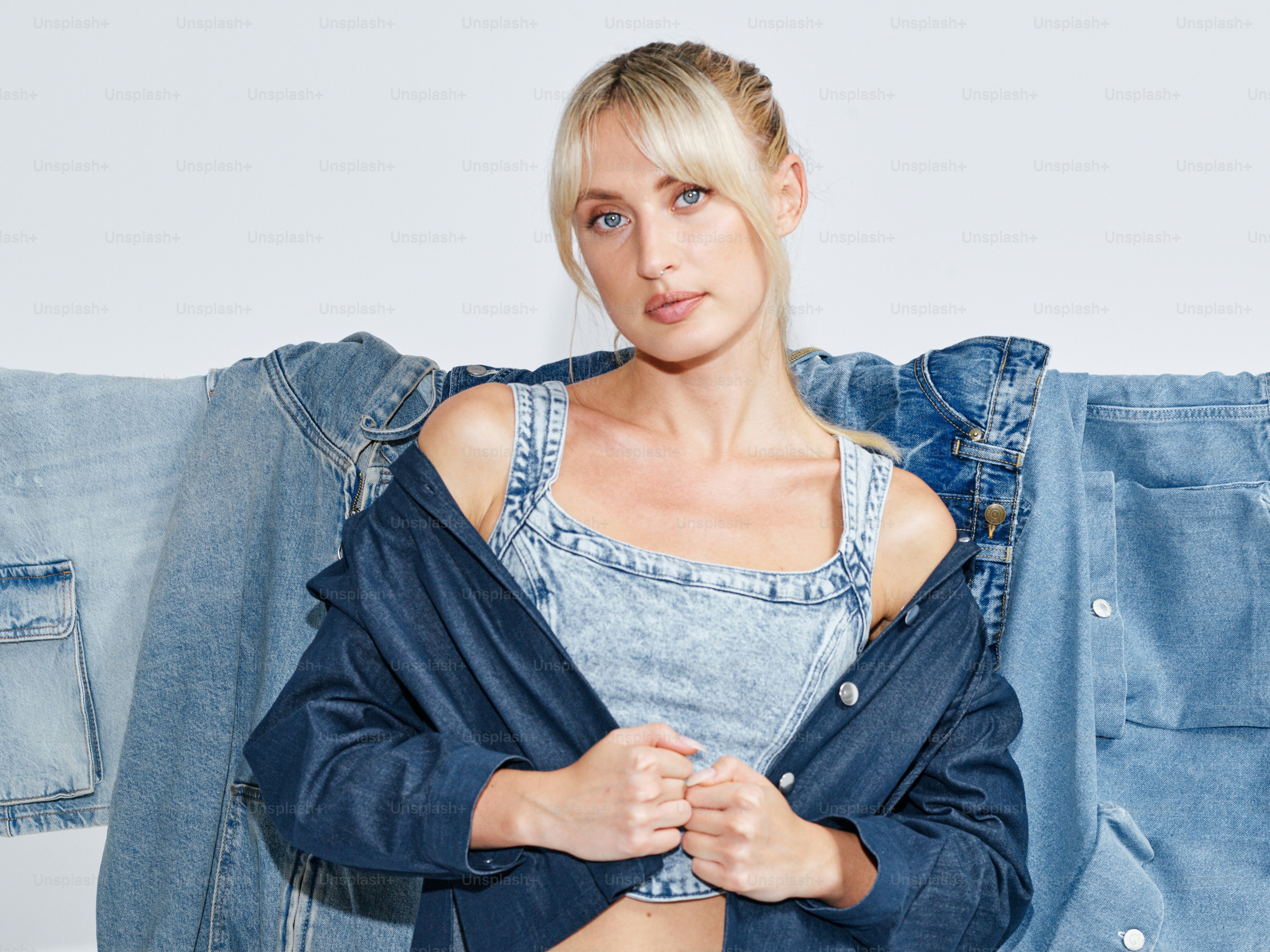 A woman standing in front of a pile of jeans