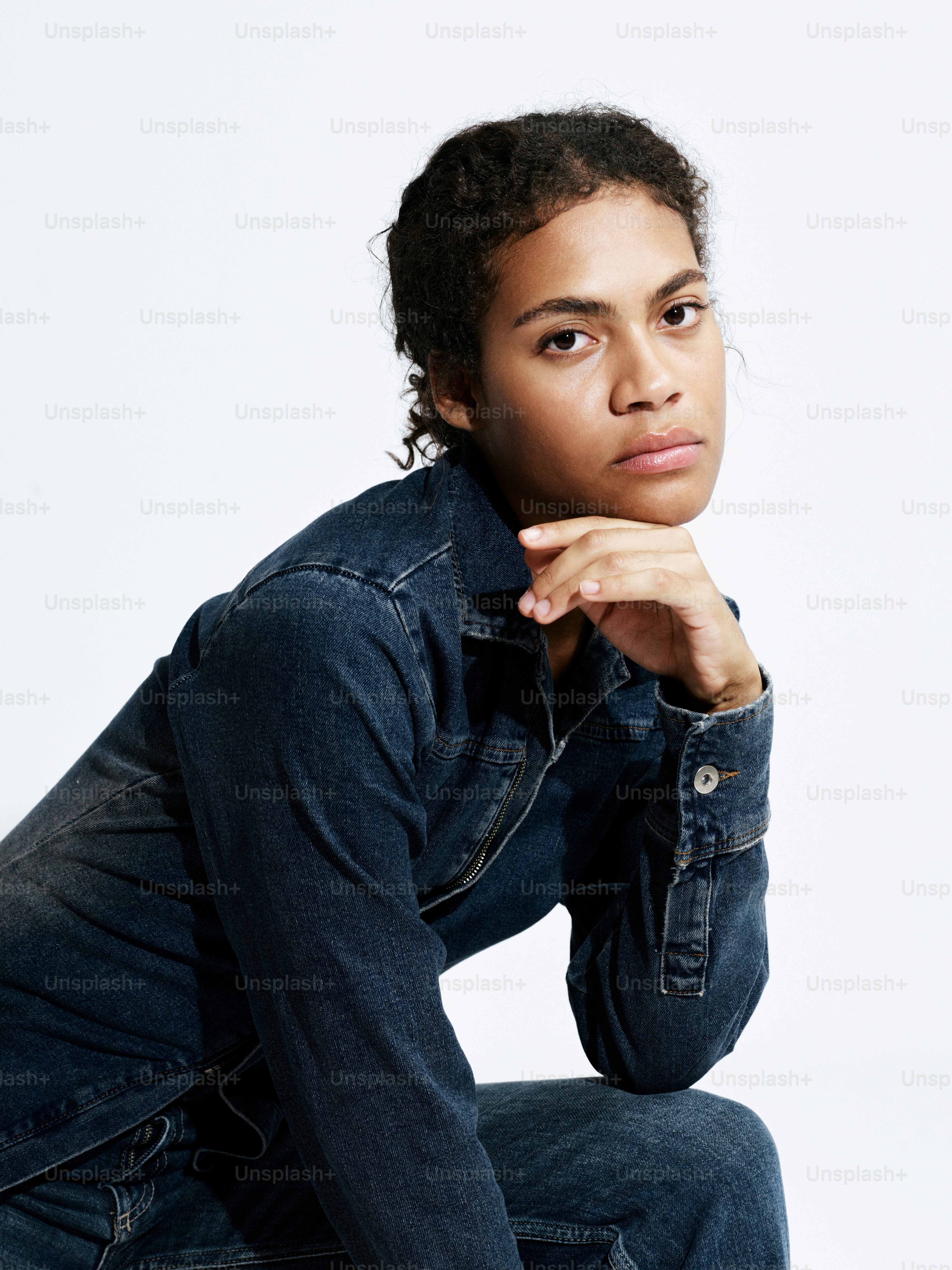 A woman sitting on the ground wearing a jean jacket photo – Portrait ...