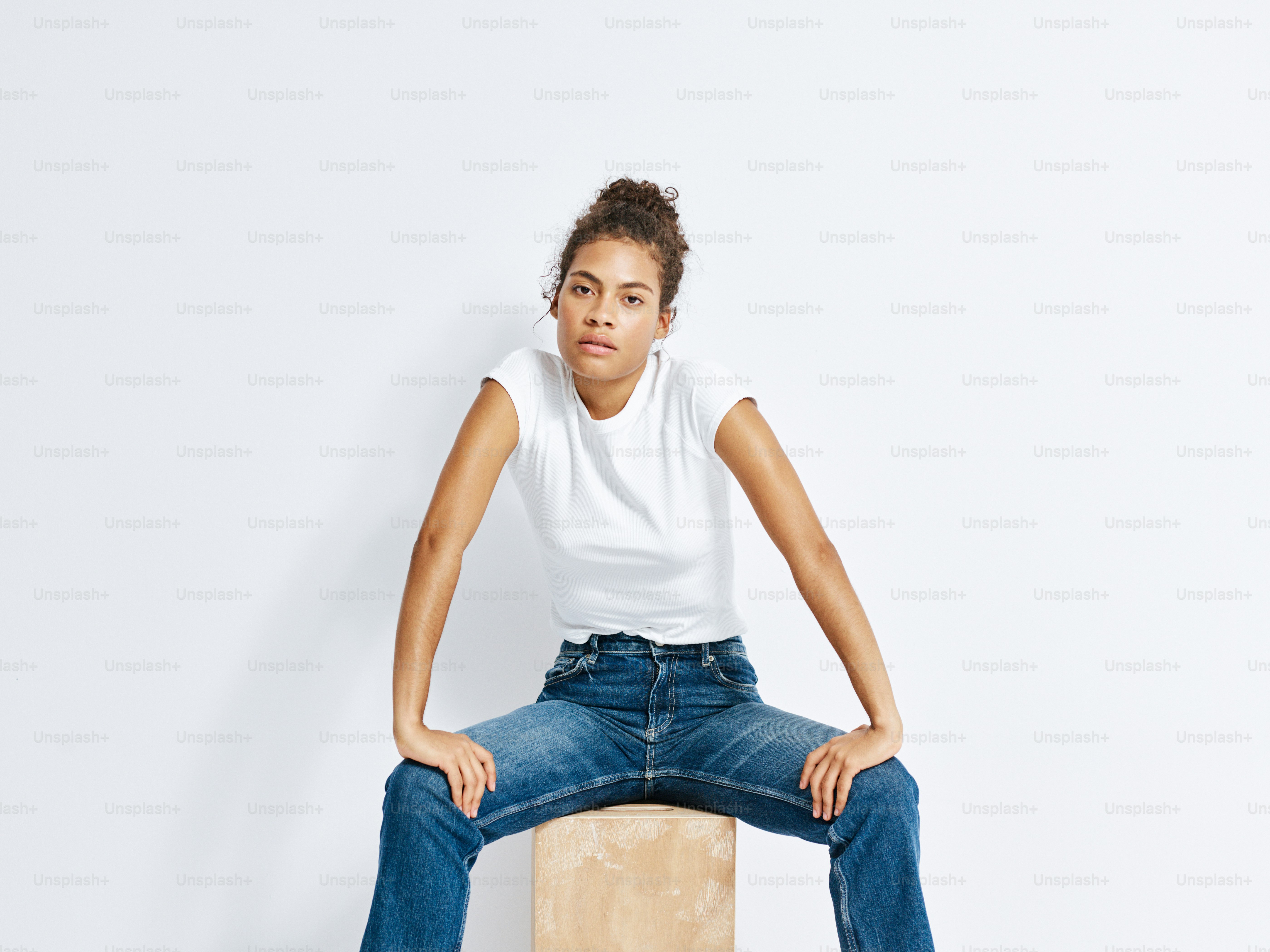 A woman sitting on top of a wooden block