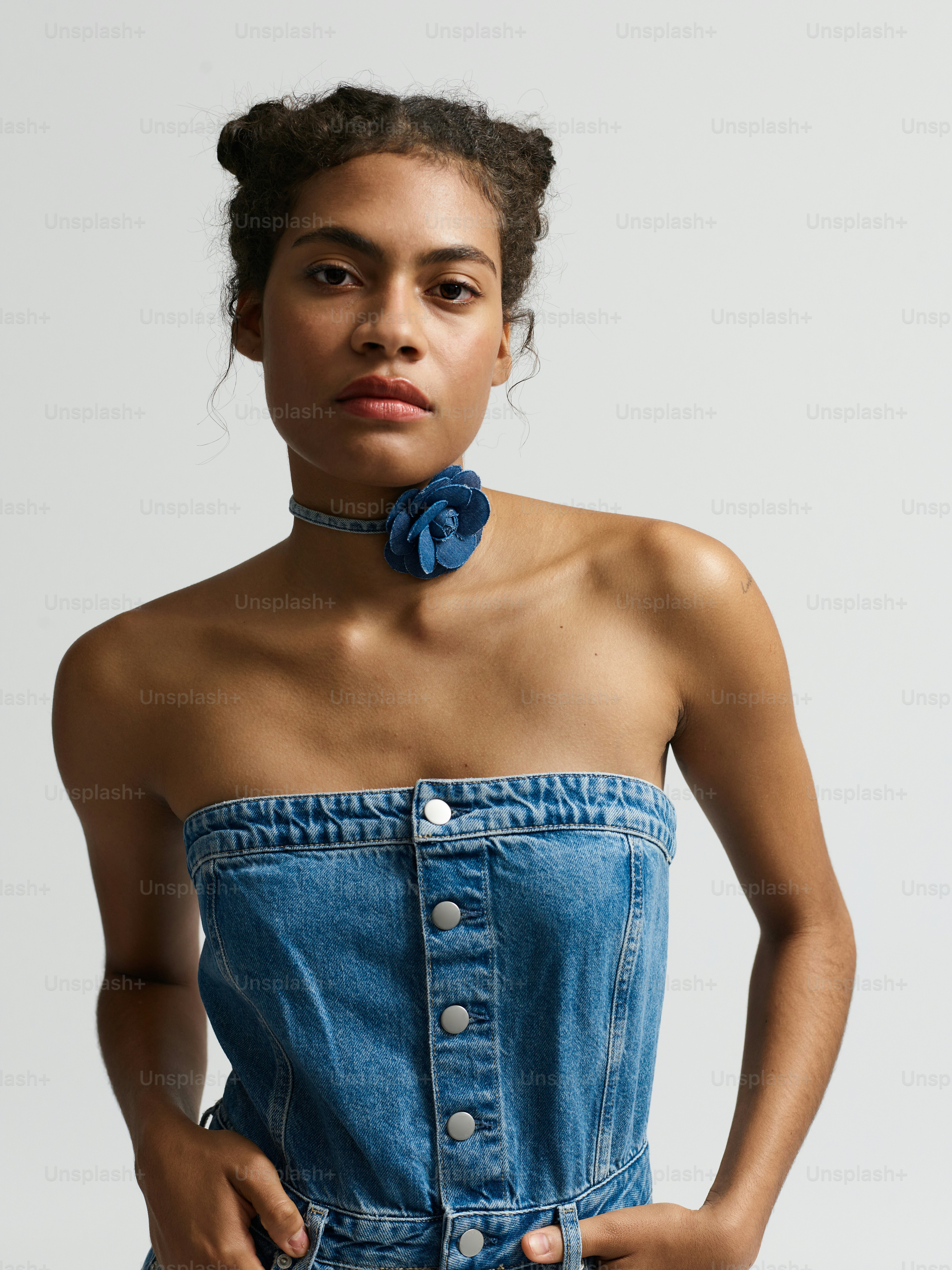 A woman wearing a denim dress with a flower in her hair