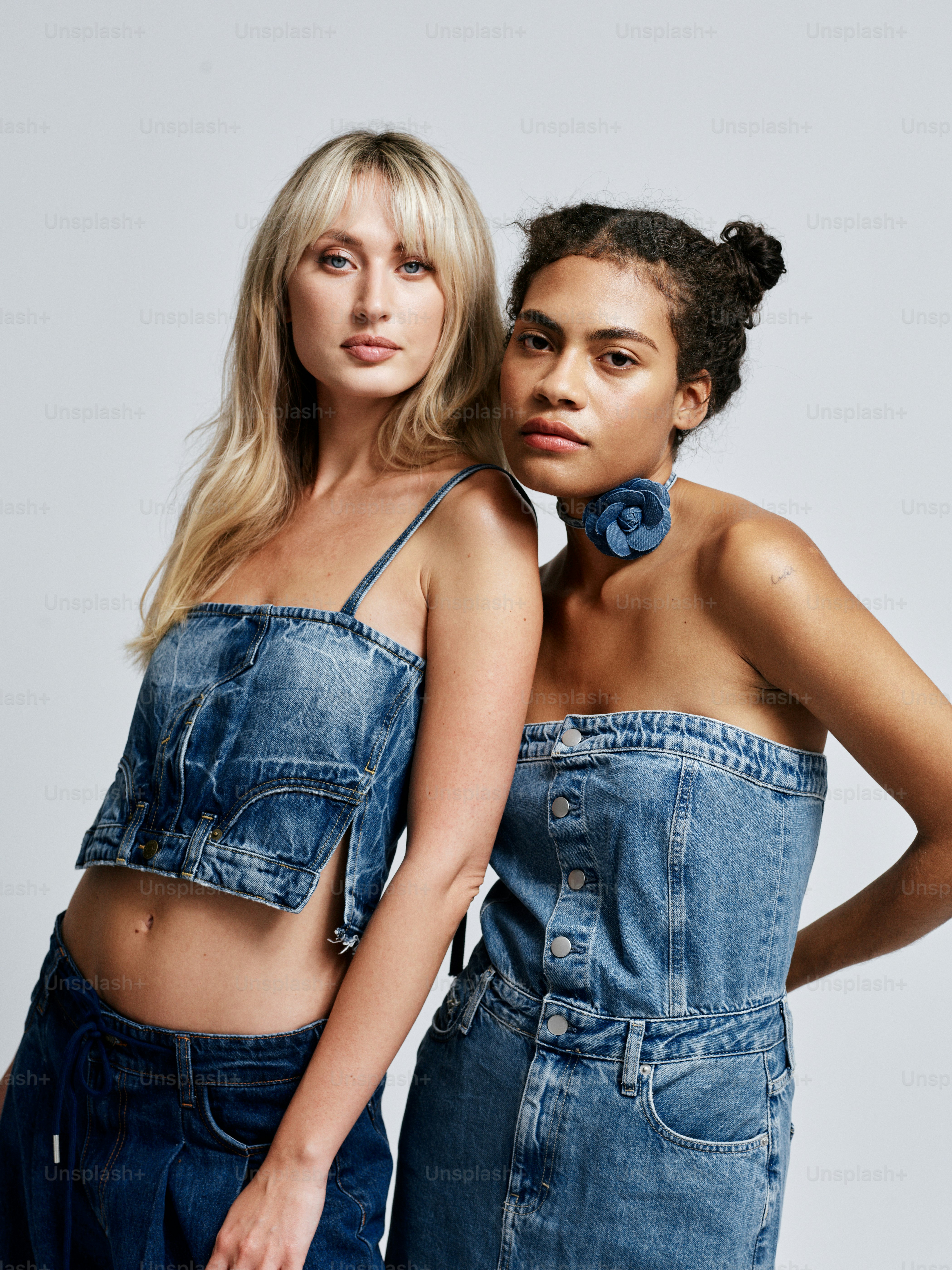 Two women standing next to each other in denim outfits