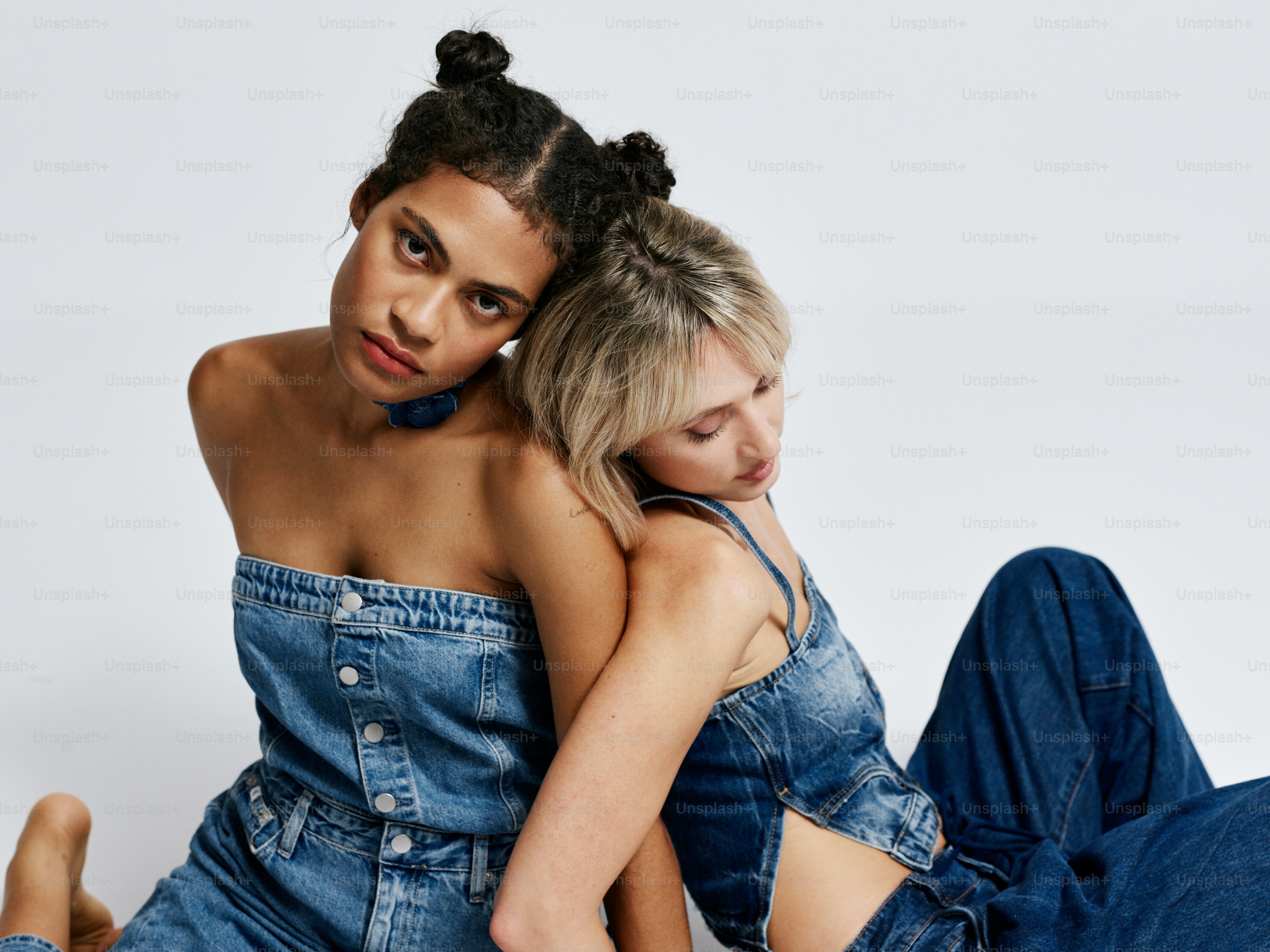 Two women sitting on the ground with their arms around each other