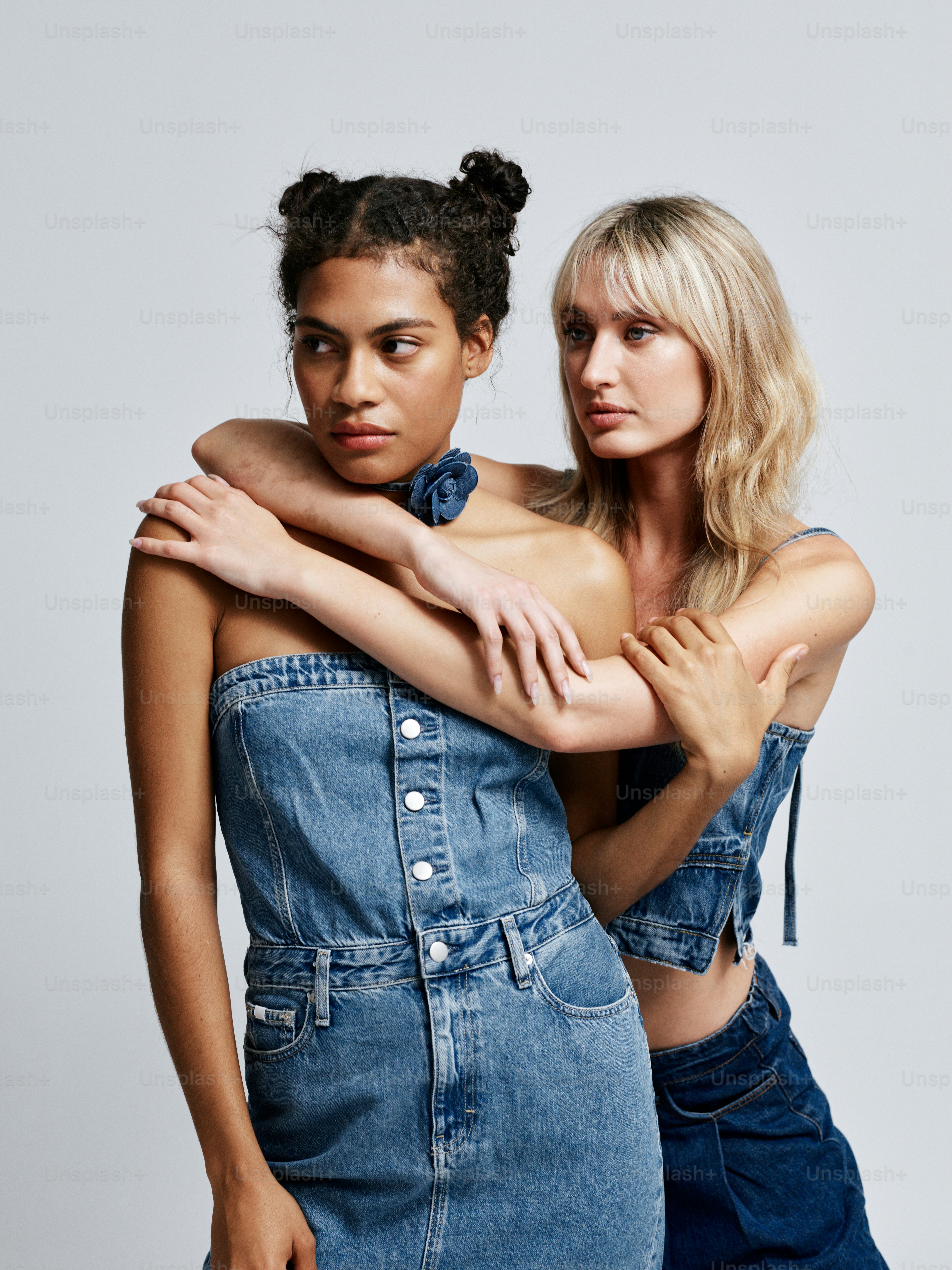 Two women in denim dresses hugging each other