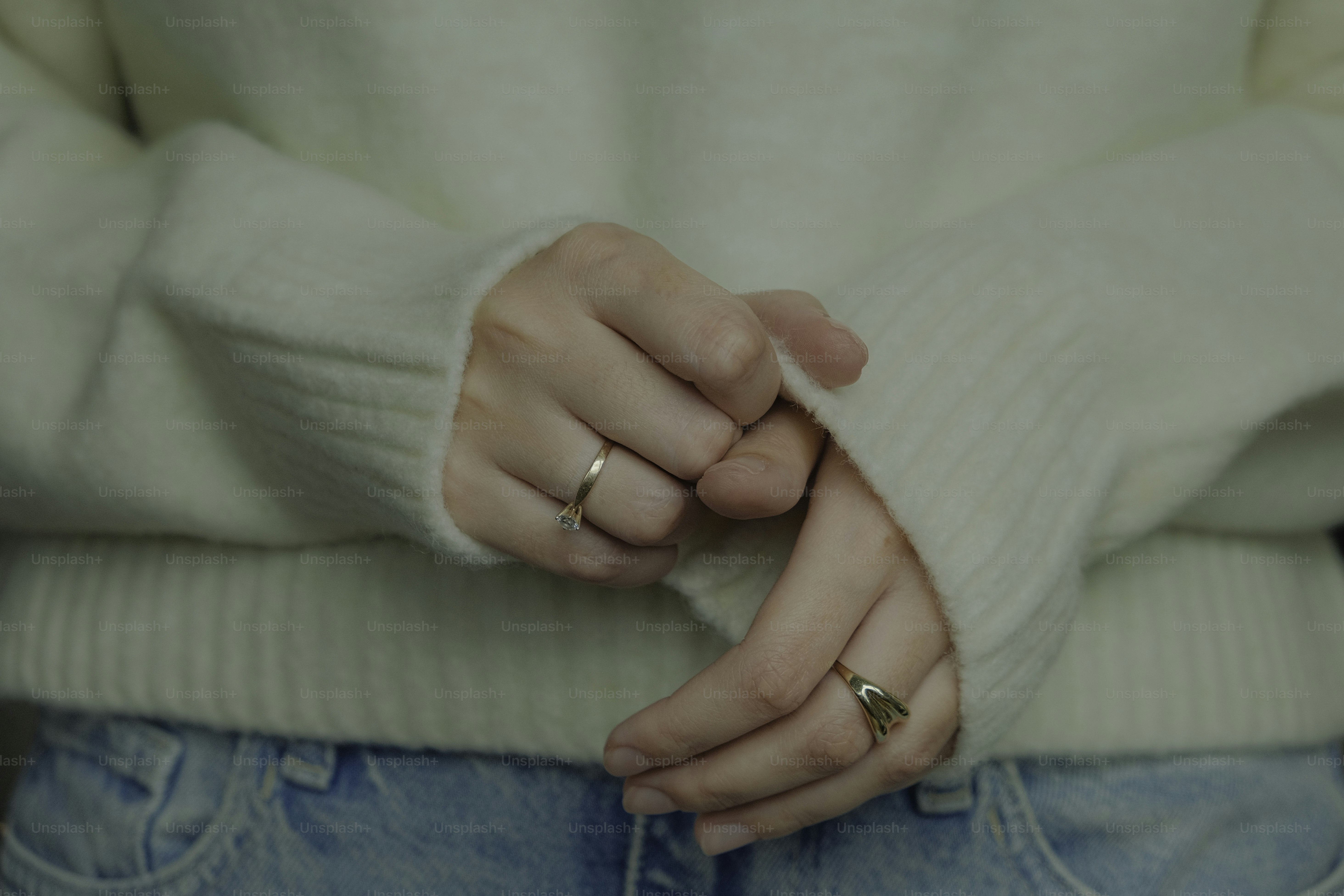 A woman wearing a white sweater and blue jeans