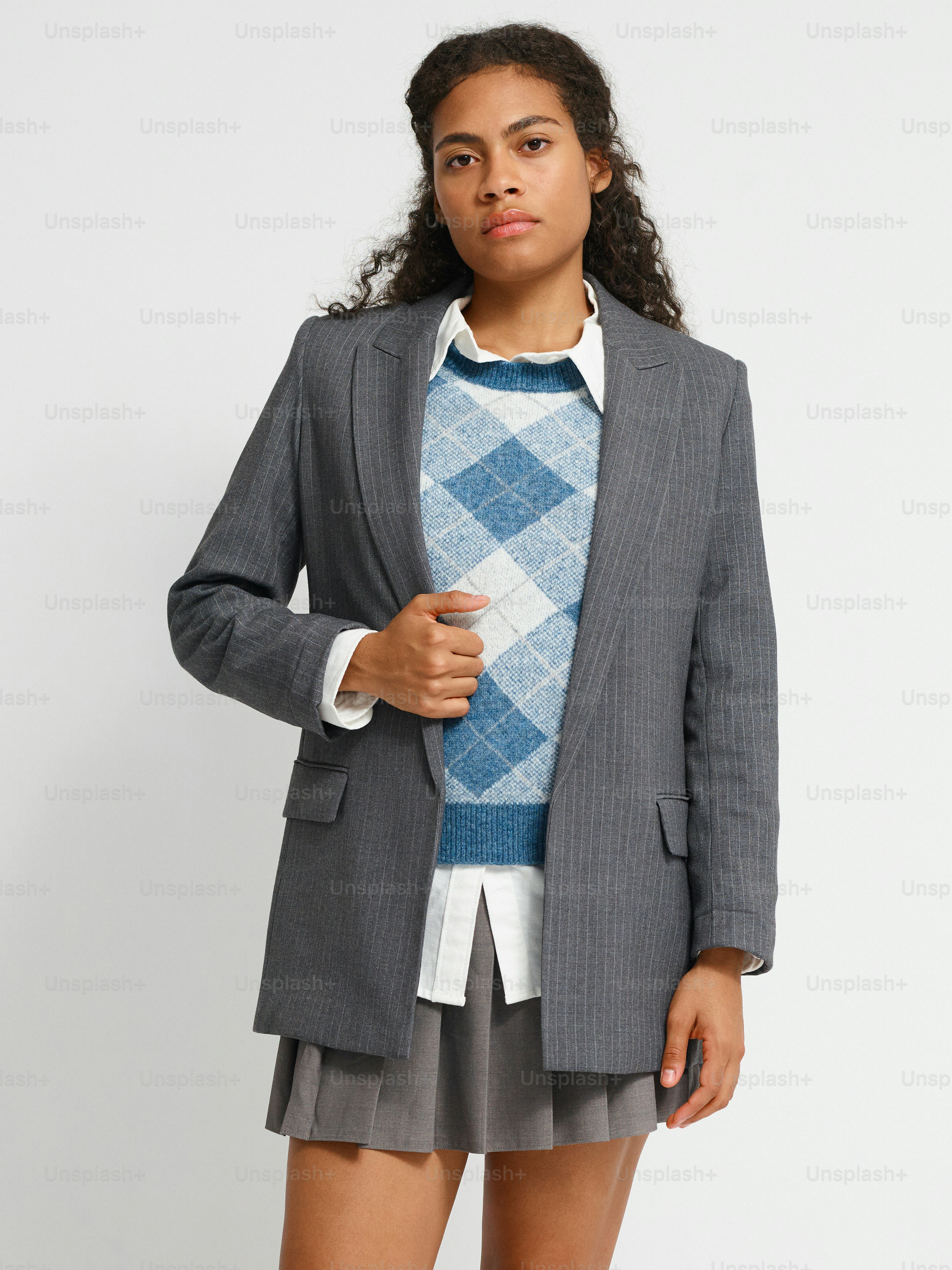 Une femme en jupe et veste posant pour une photo