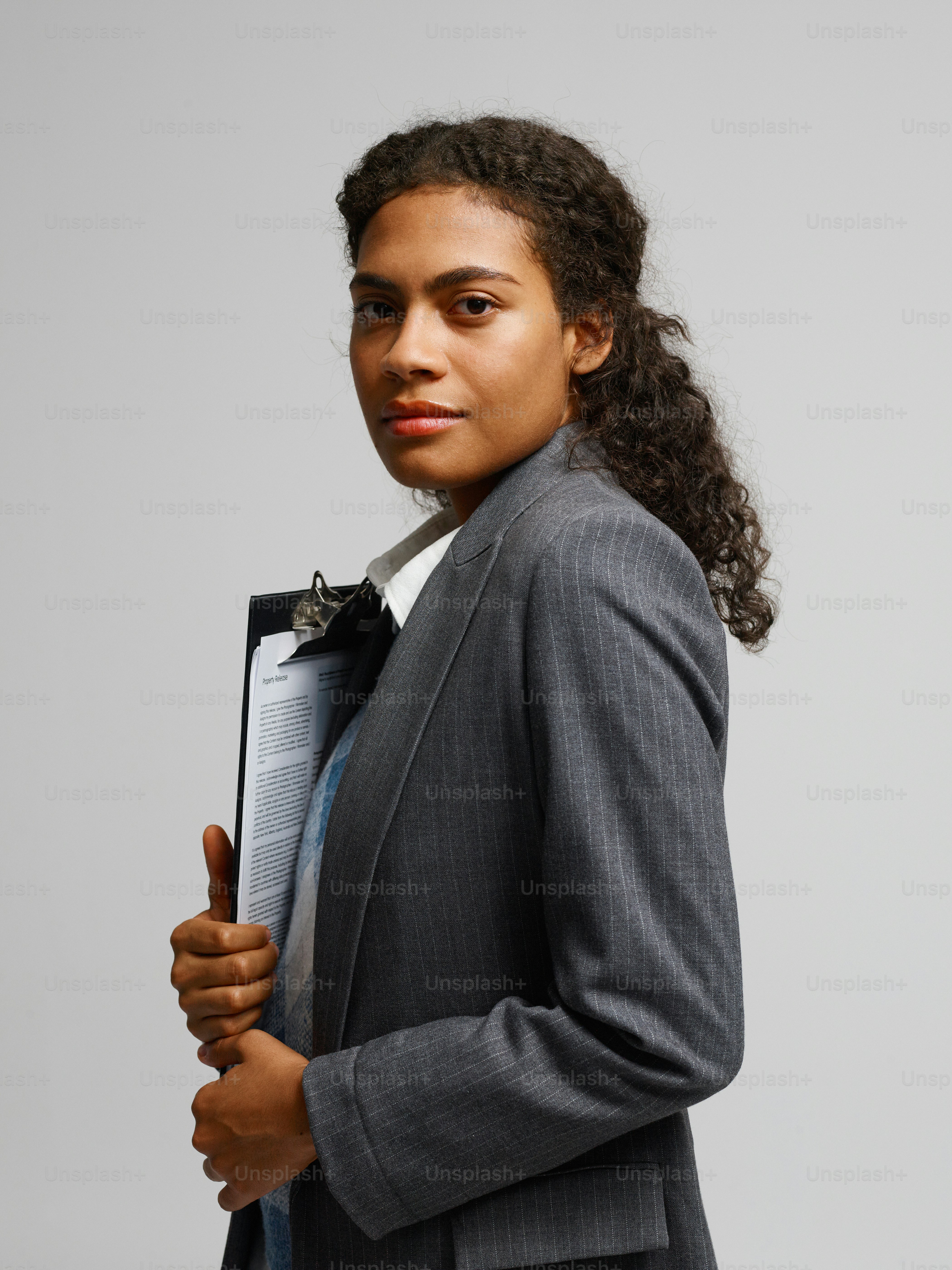 Une femme en costume tenant un dossier