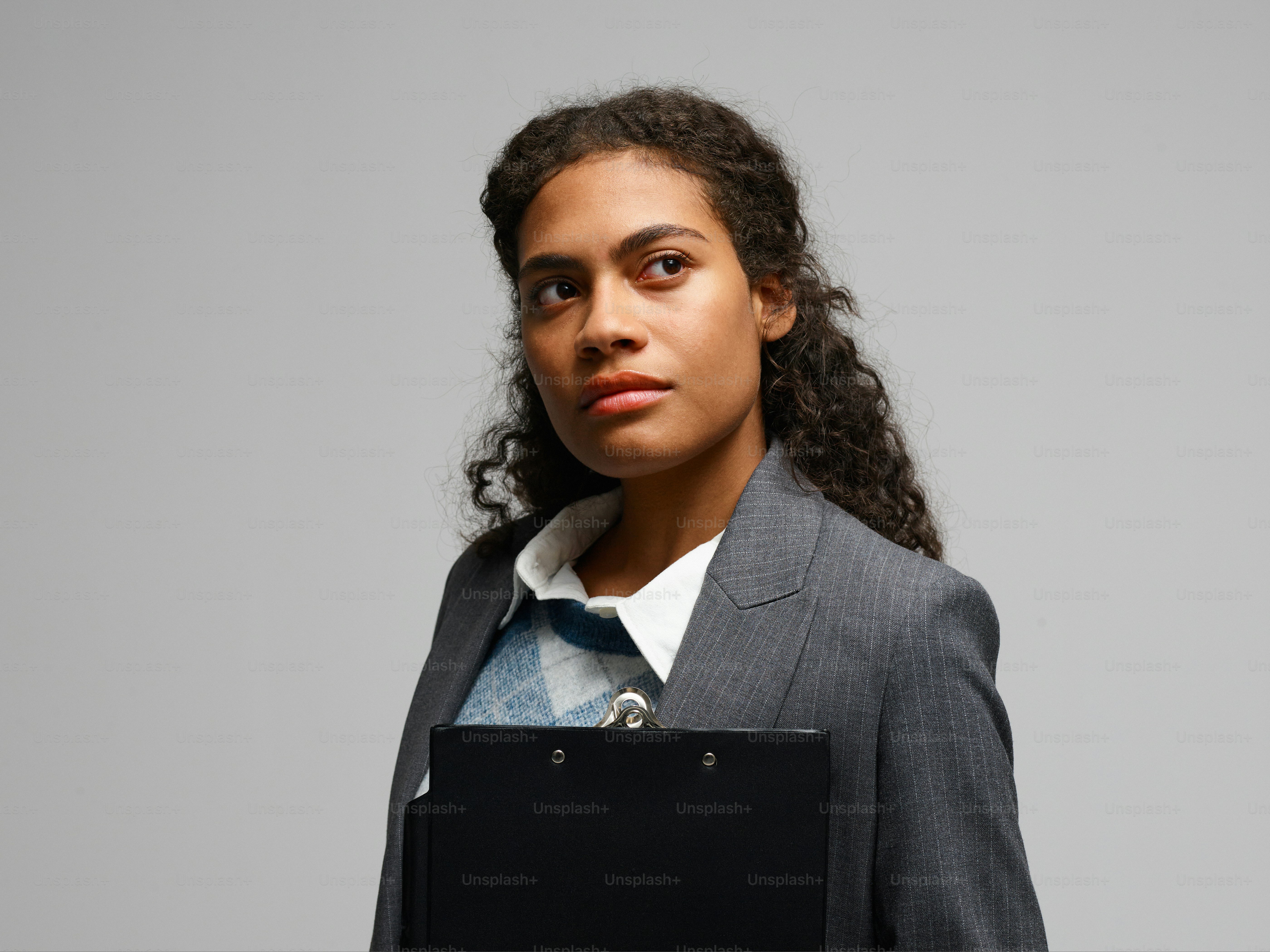 Une femme en costume tenant un ordinateur portable