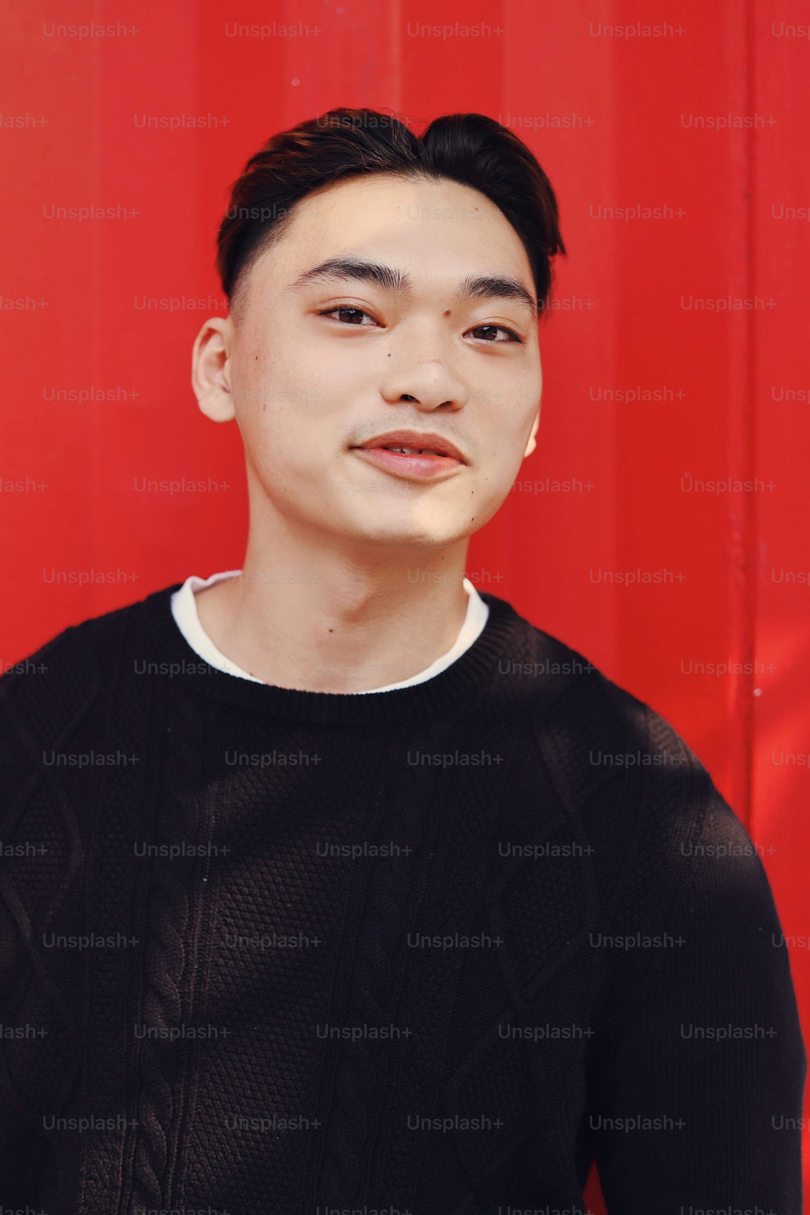 A man standing in front of a red wall
