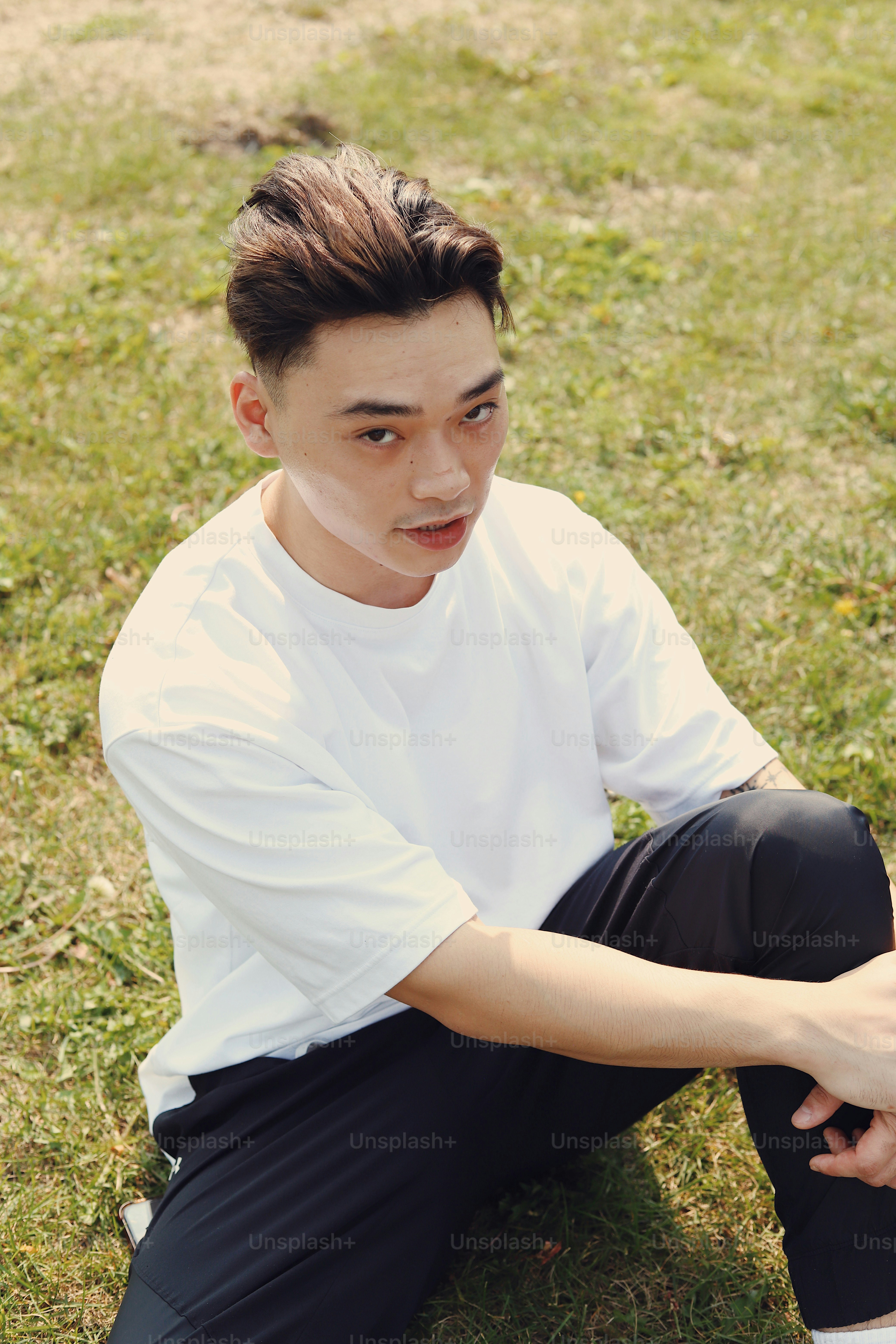 フリスビーを持って地面に座っている若い男性