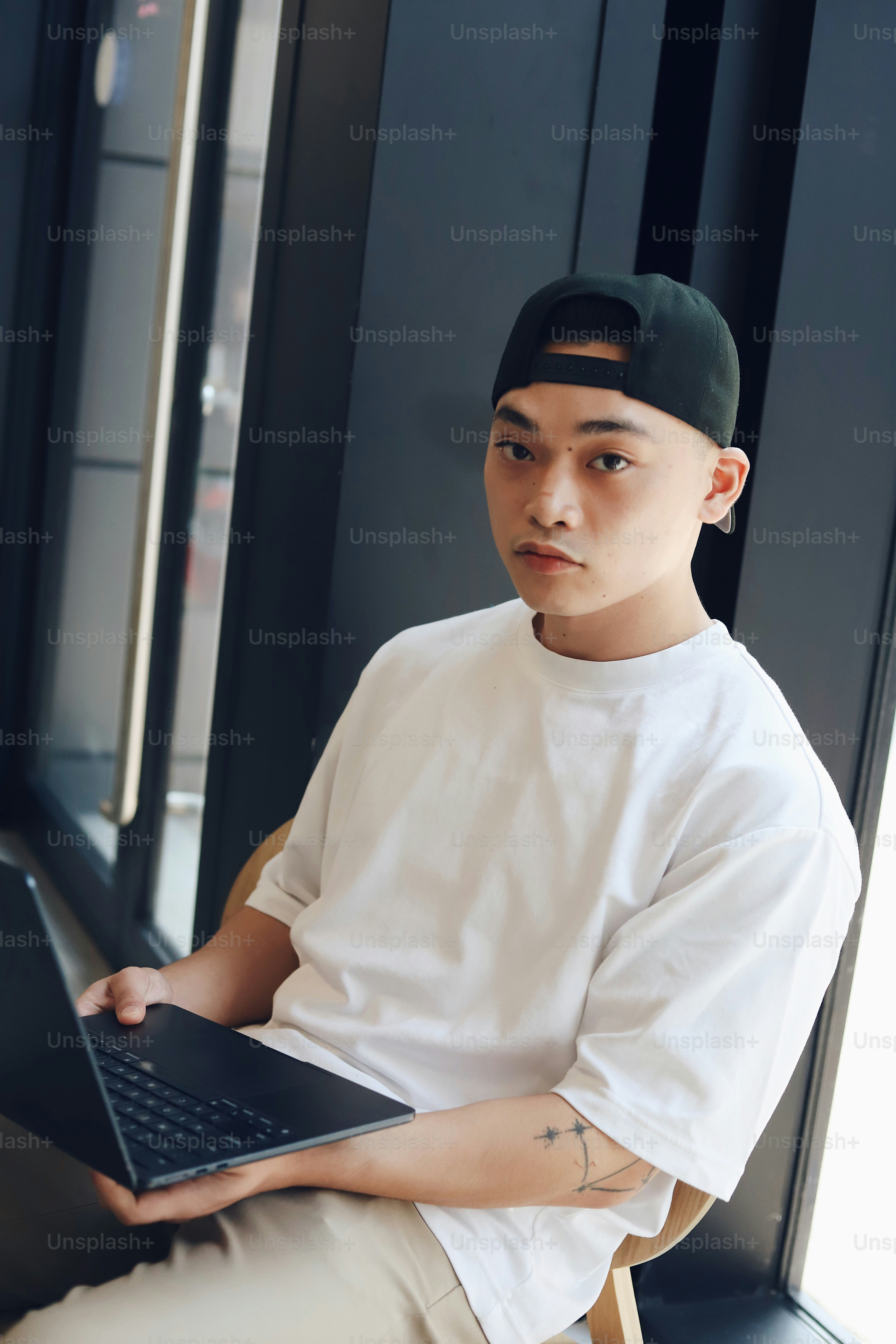 A man sitting in a chair holding a laptop