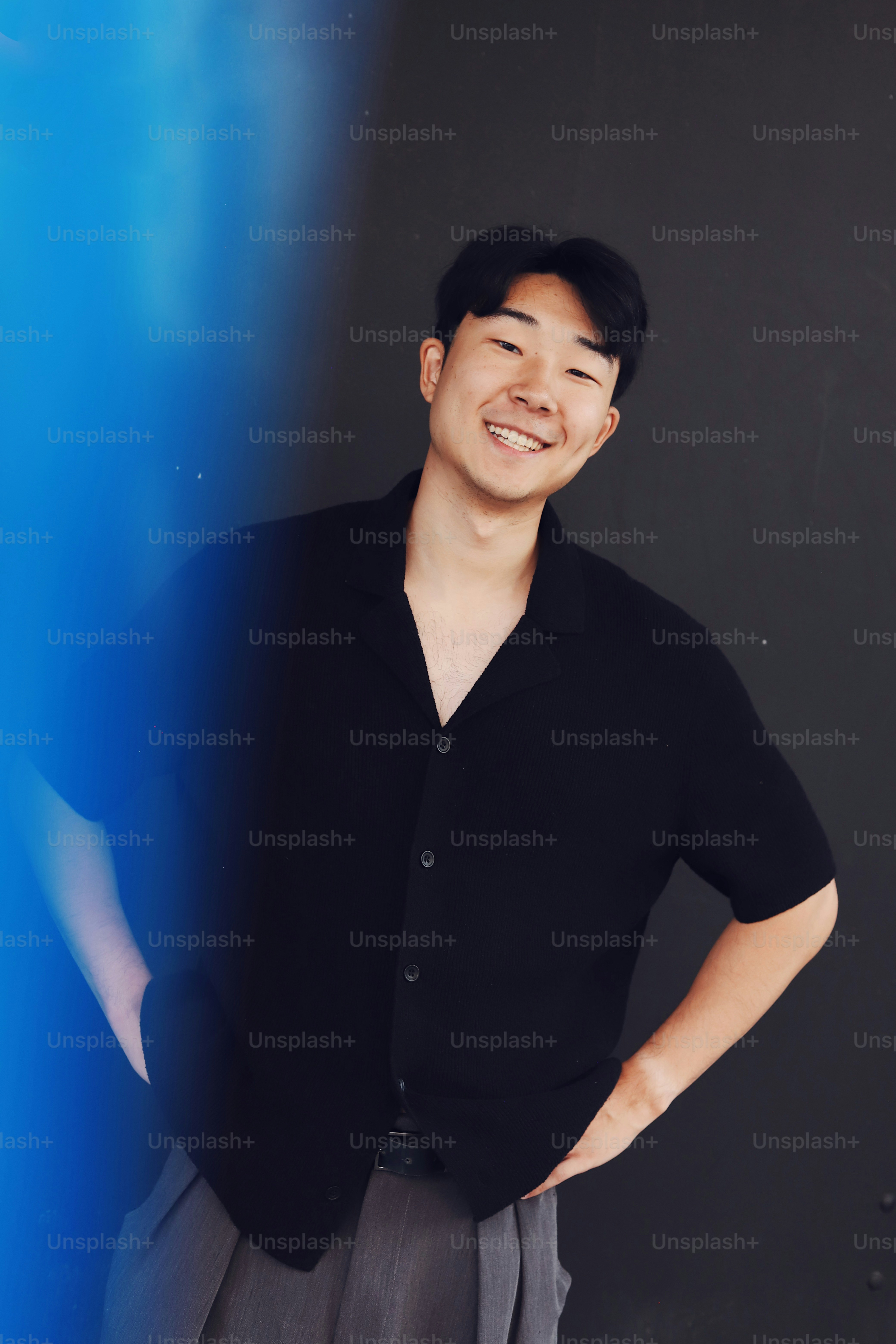 A man standing in front of a blue and black wall