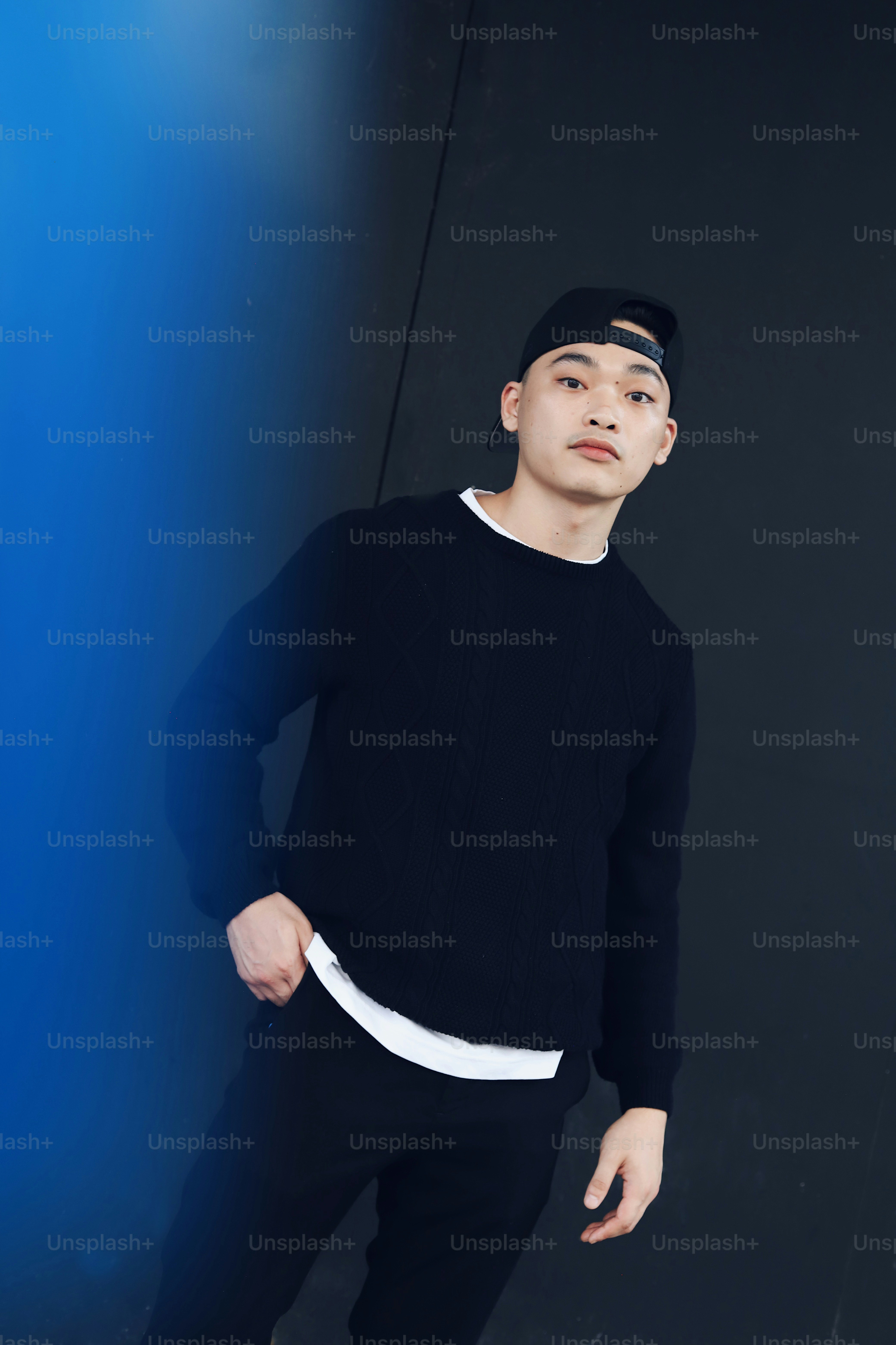 A man standing in front of a black wall