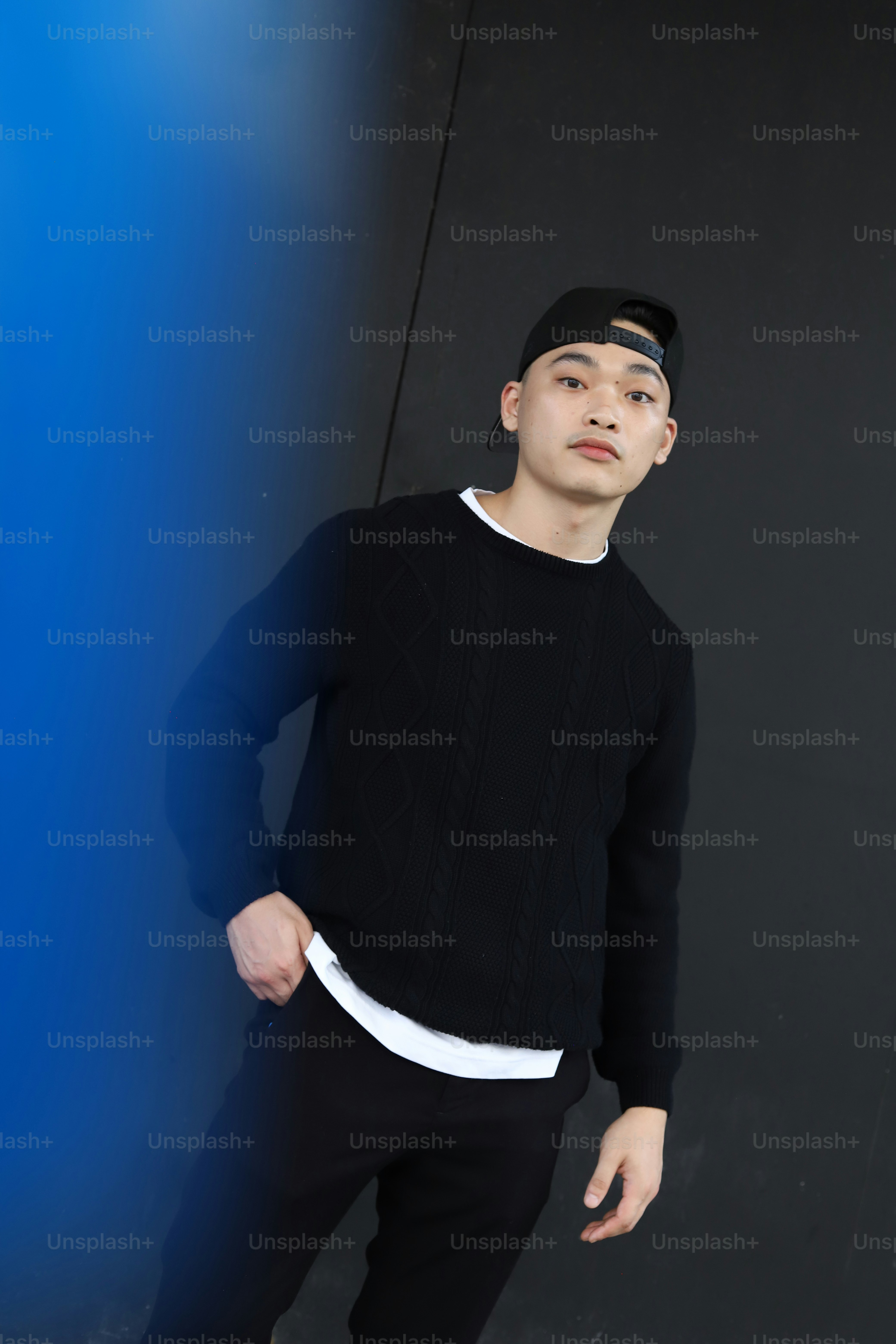 A man standing in front of a black wall photo – Streetwear Image on ...