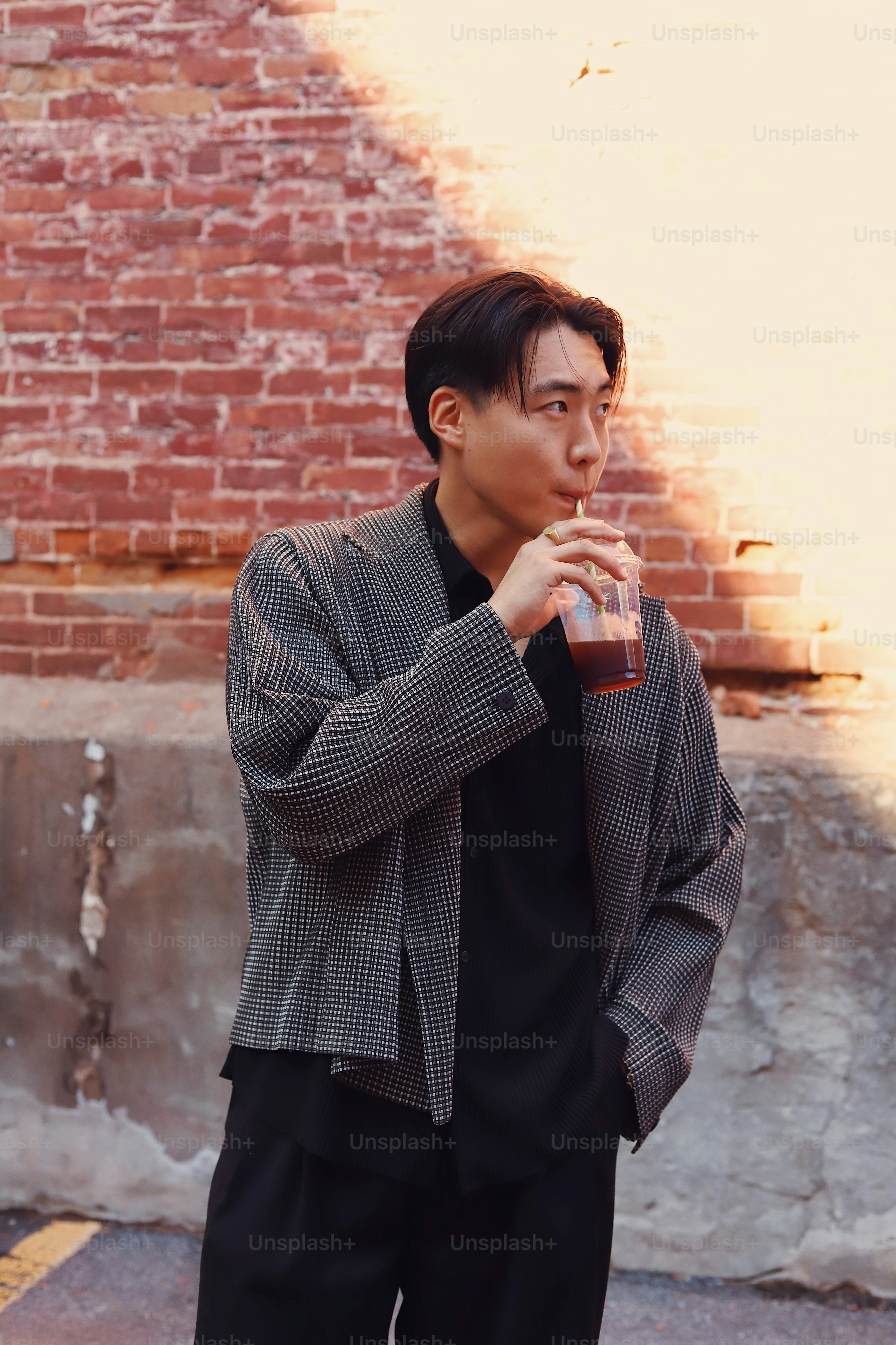 A man standing in front of a brick wall photo – Purple Image on Unsplash