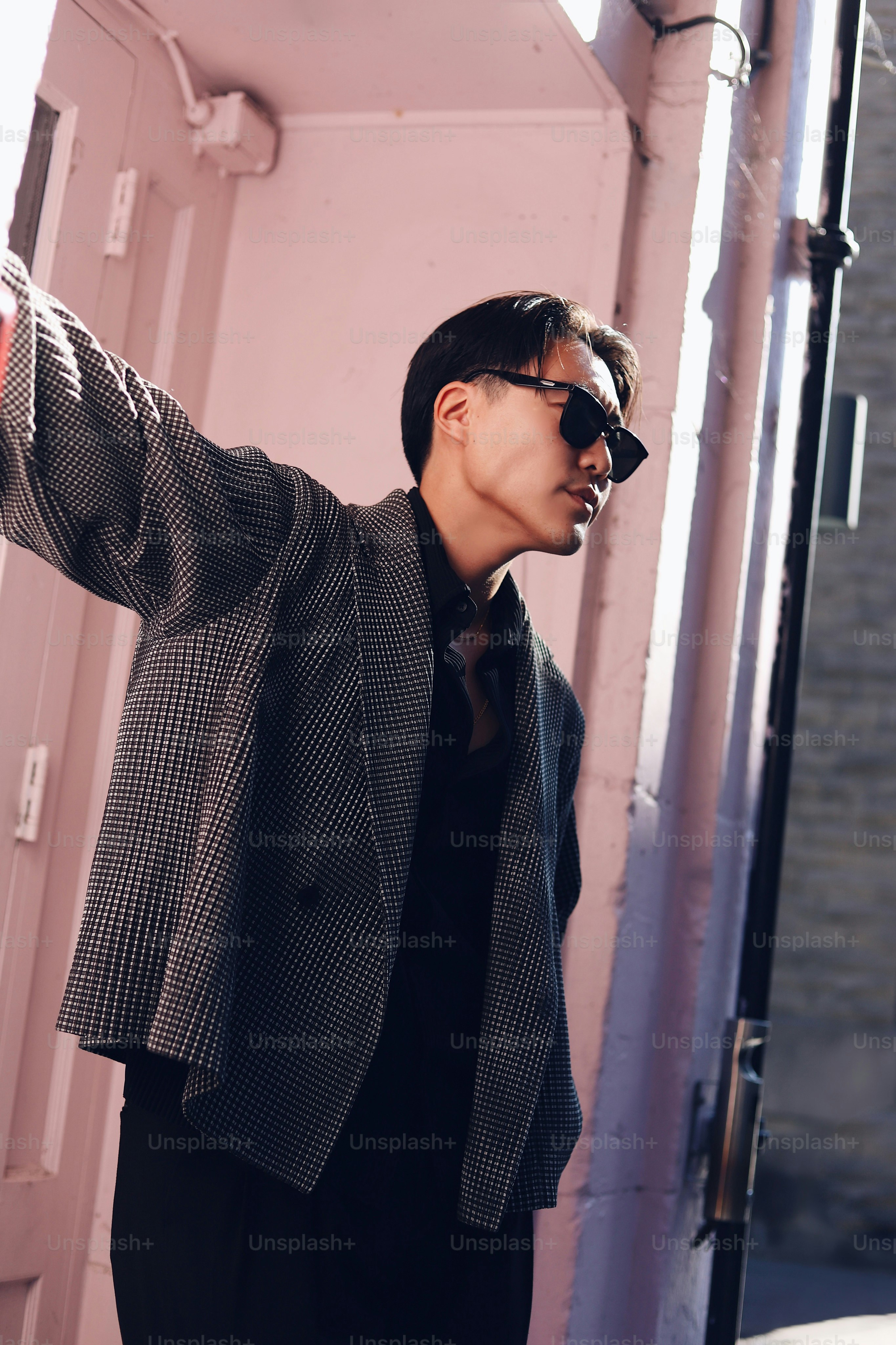 A man in a suit and sunglasses standing in a doorway