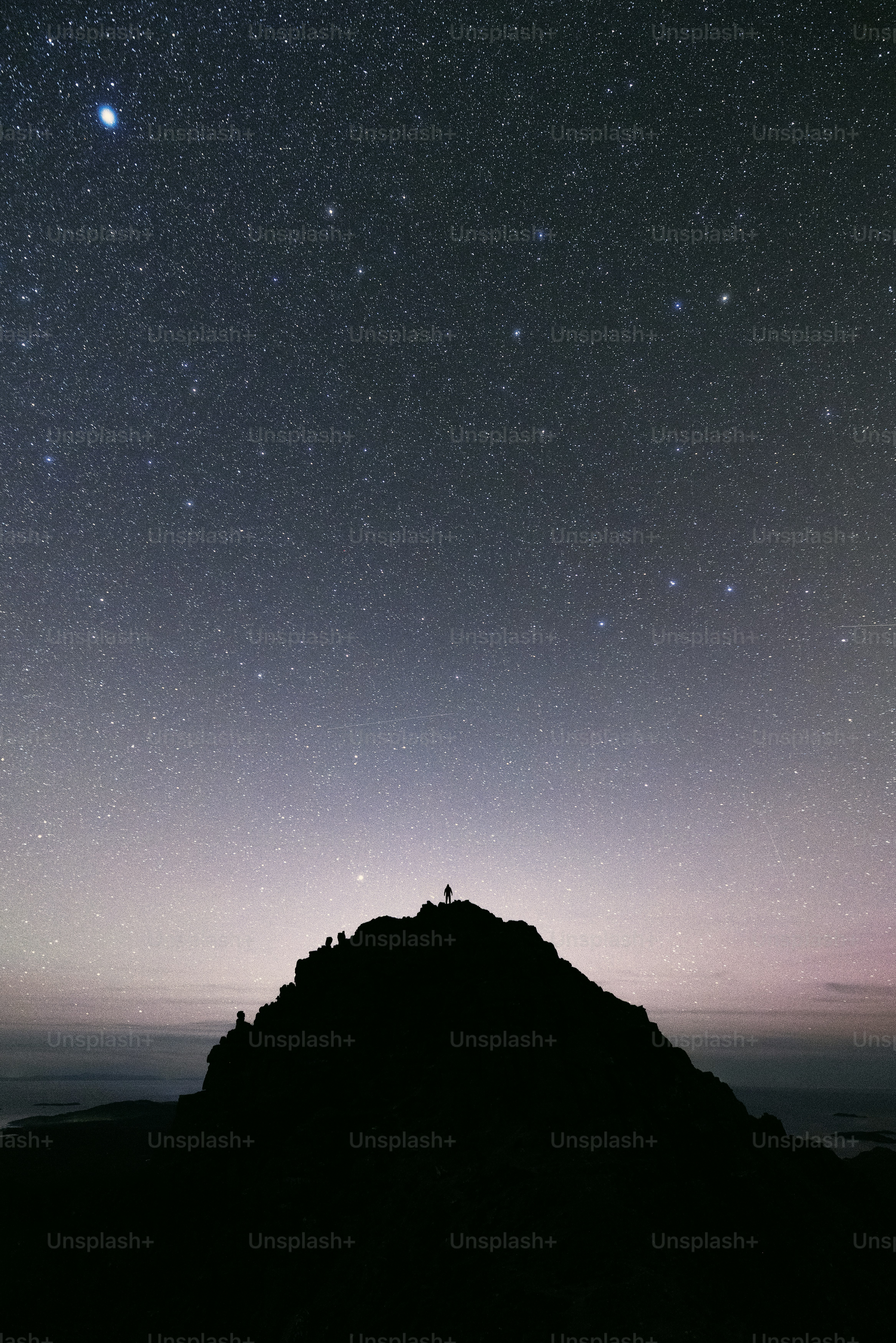 The night sky with stars above a mountain
