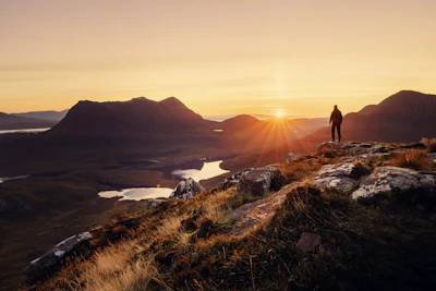 Person on mountain at sunset warm