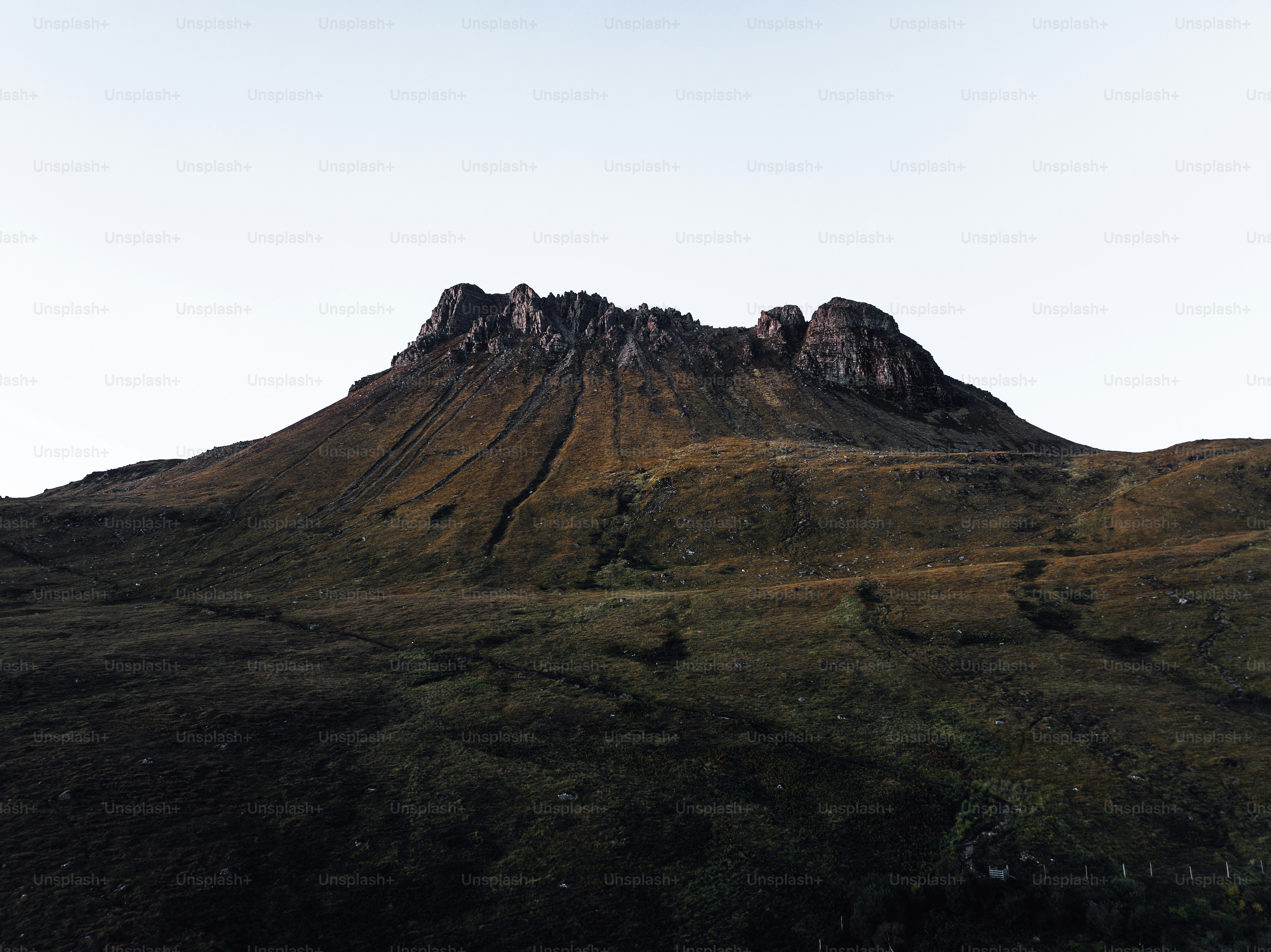 A very tall mountain with a sky in the background