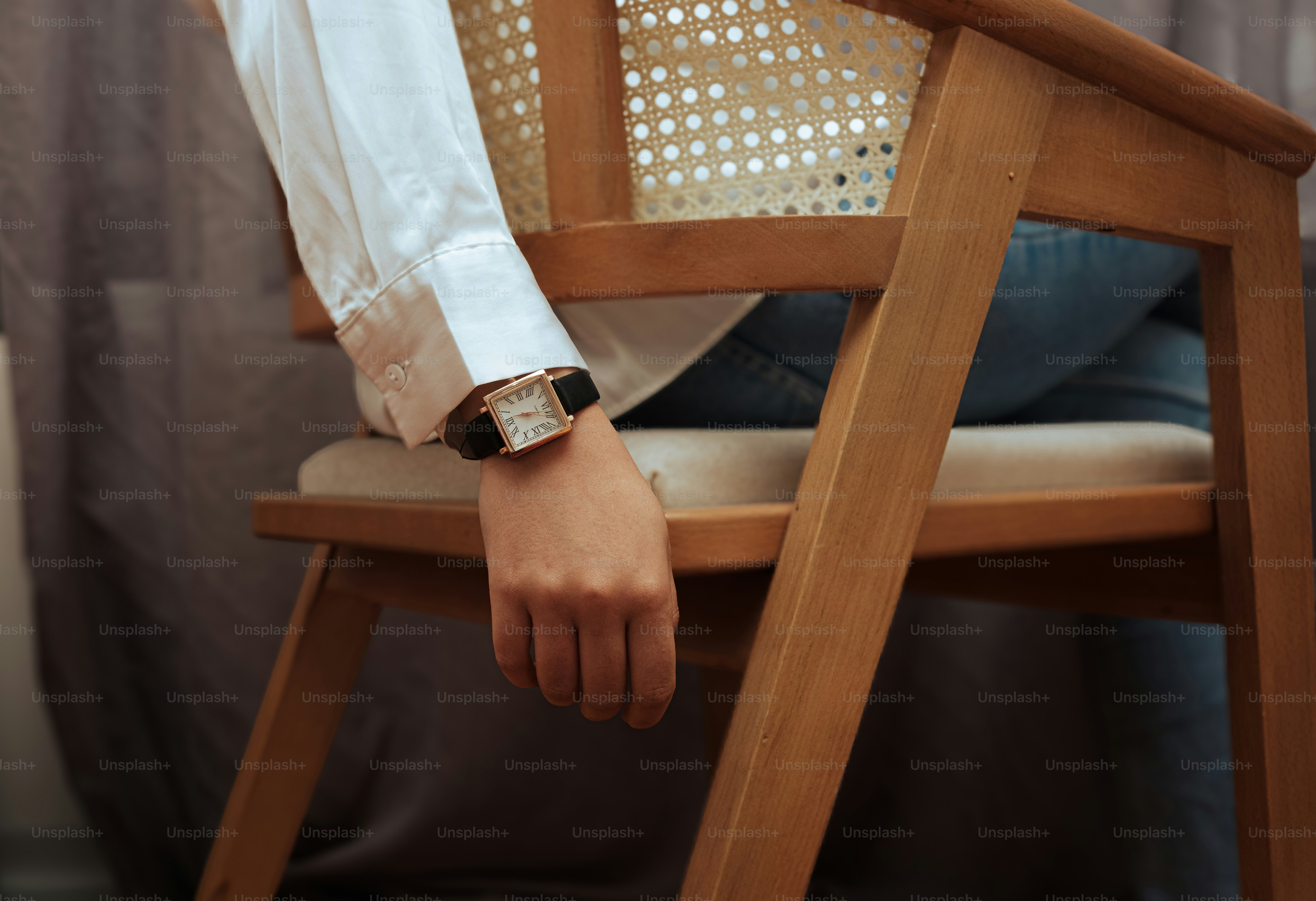 Una donna seduta su una sedia con un orologio al polso