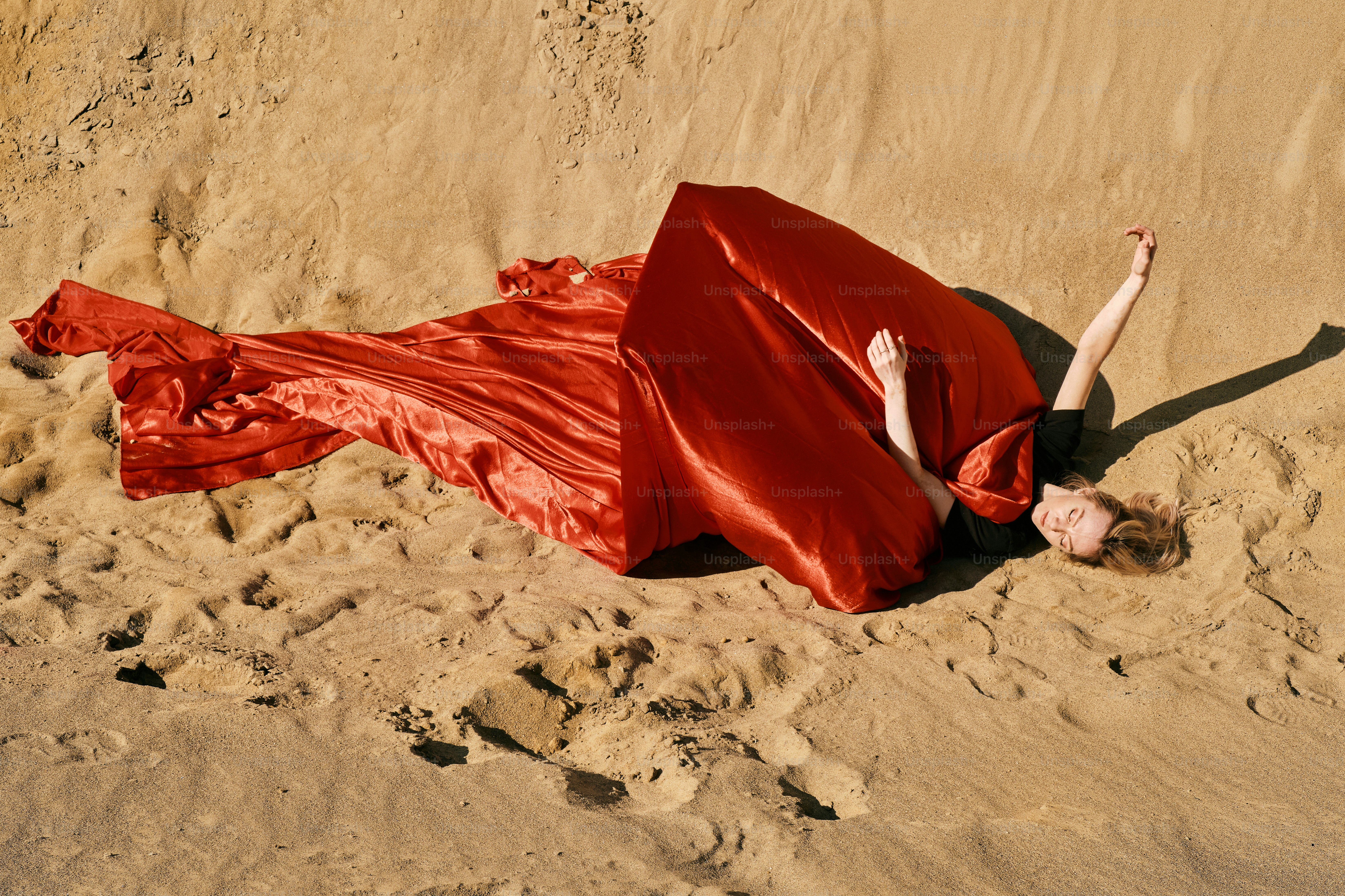 A woman in a red dress laying in the sand photo – Desert Image on Unsplash