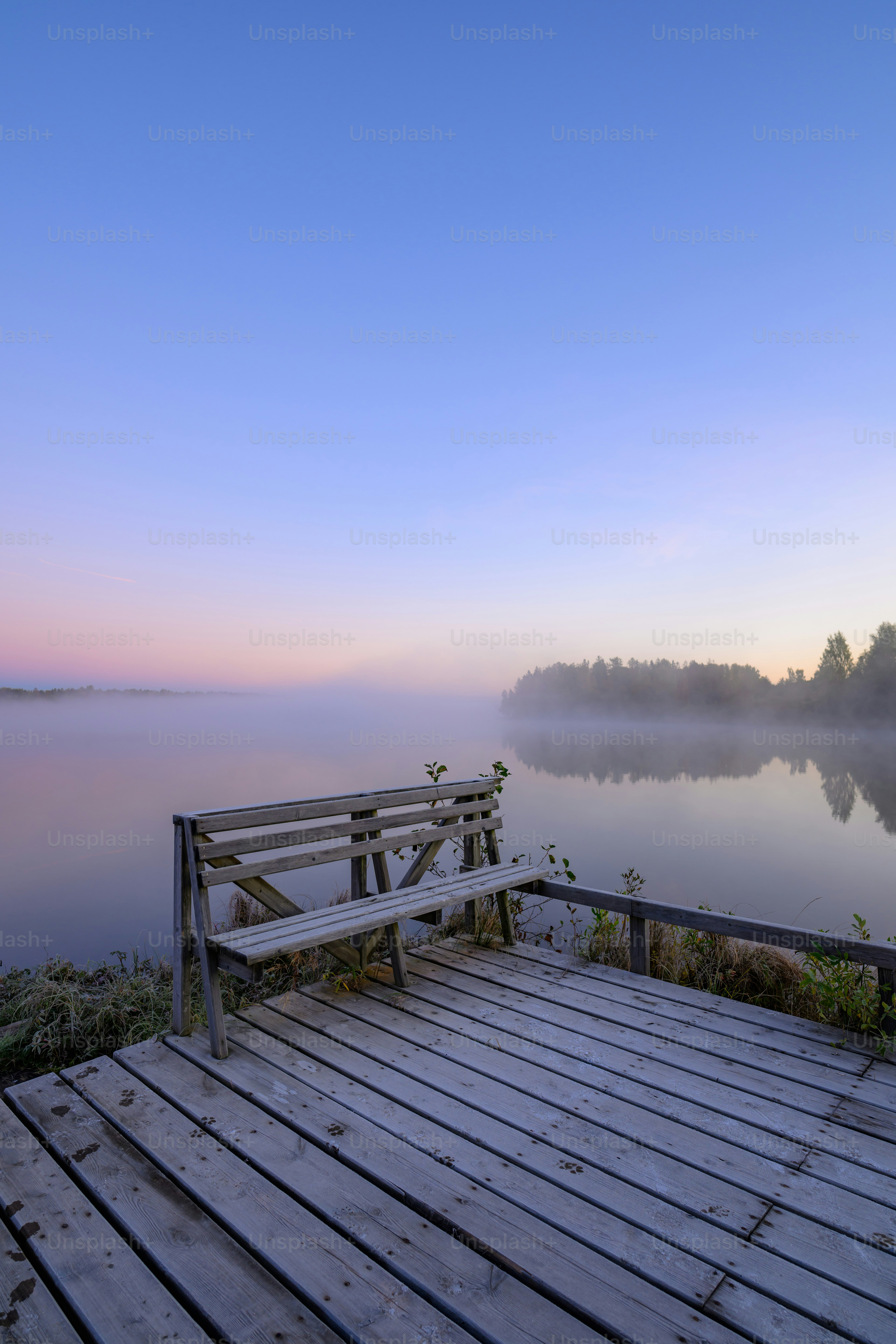 A bench sitting on top of a wooden pier next to a body of water