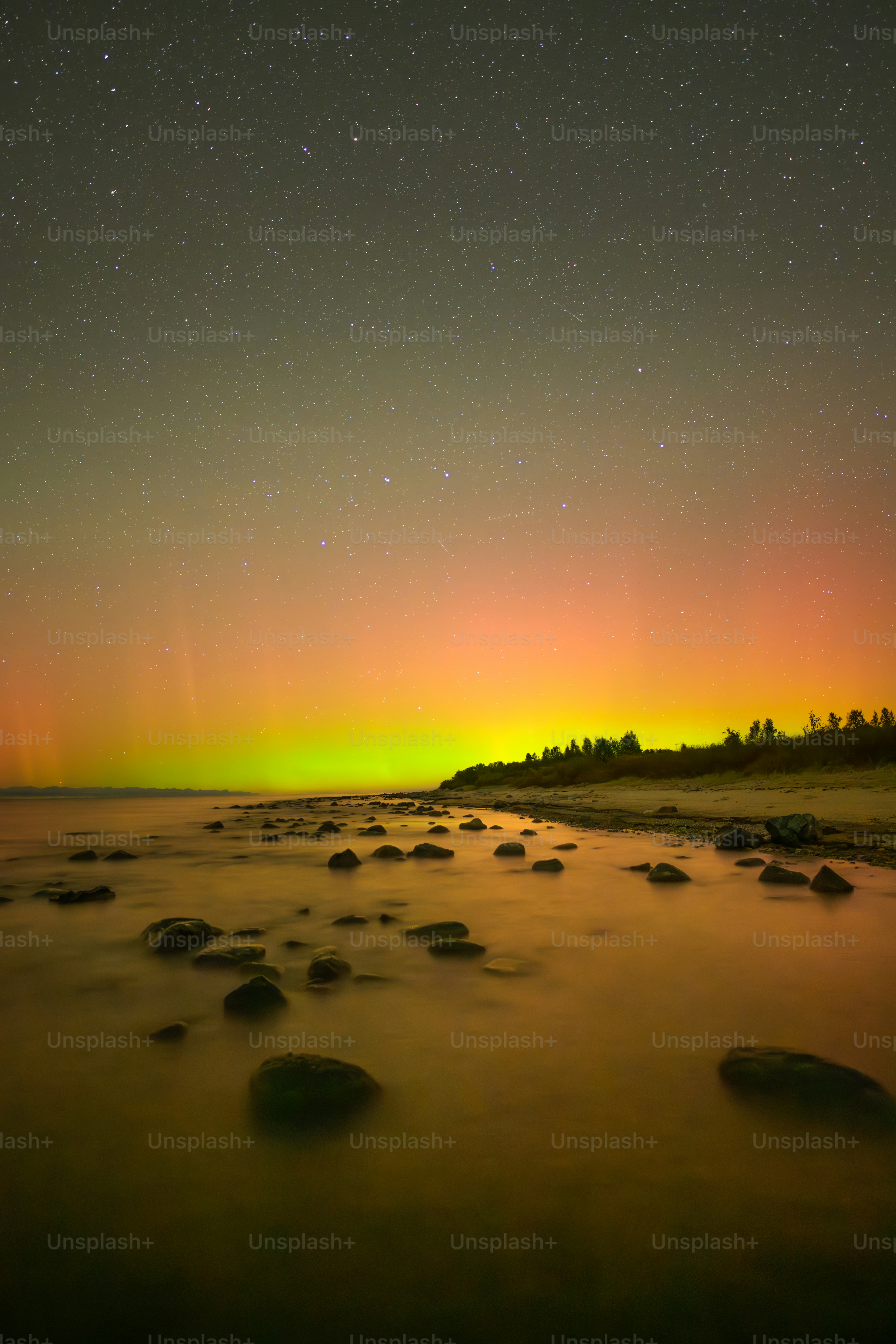 Ein grün-gelbes Polarlicht über einem Gewässer