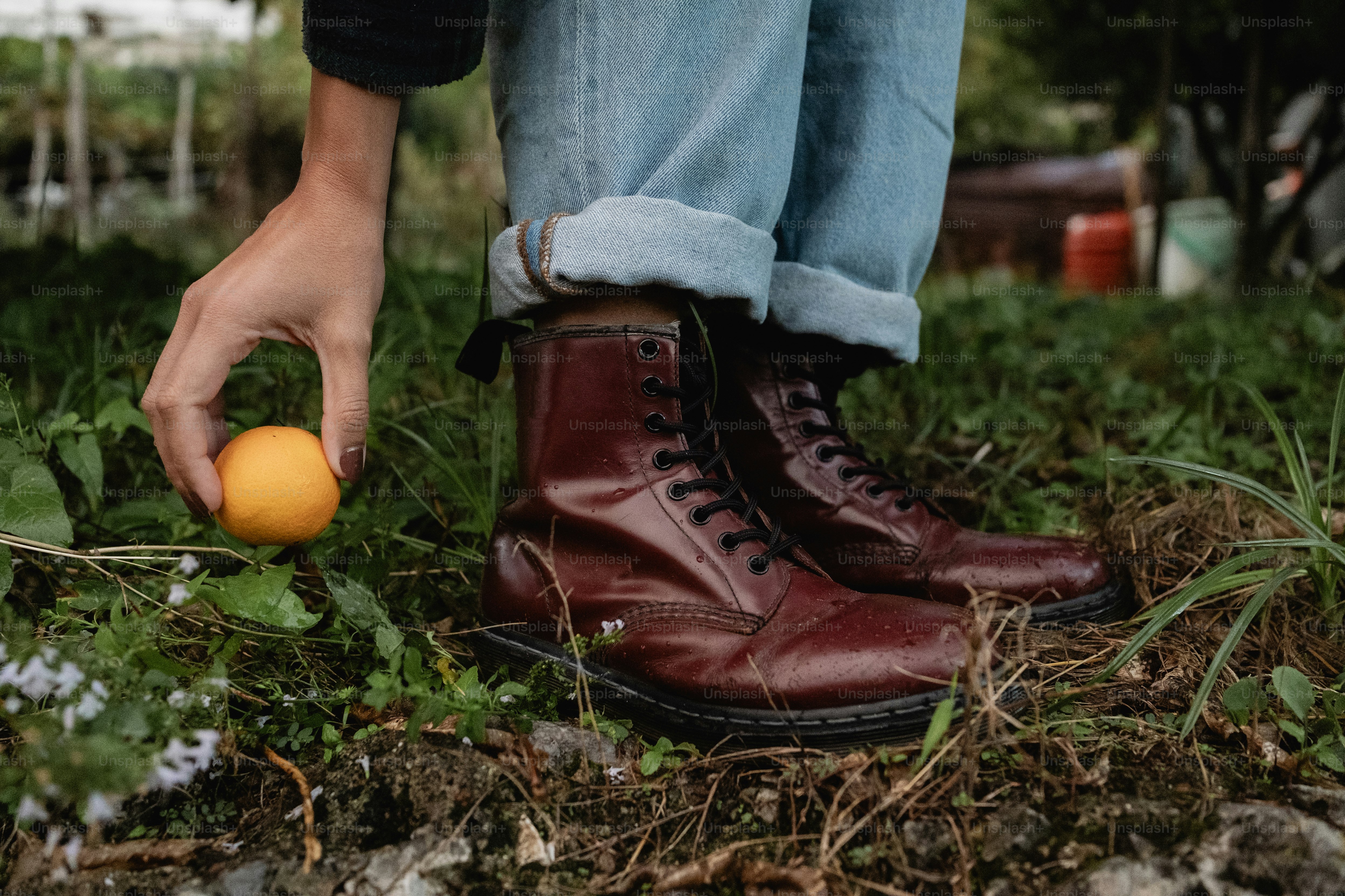 A person picking up an orange from the ground