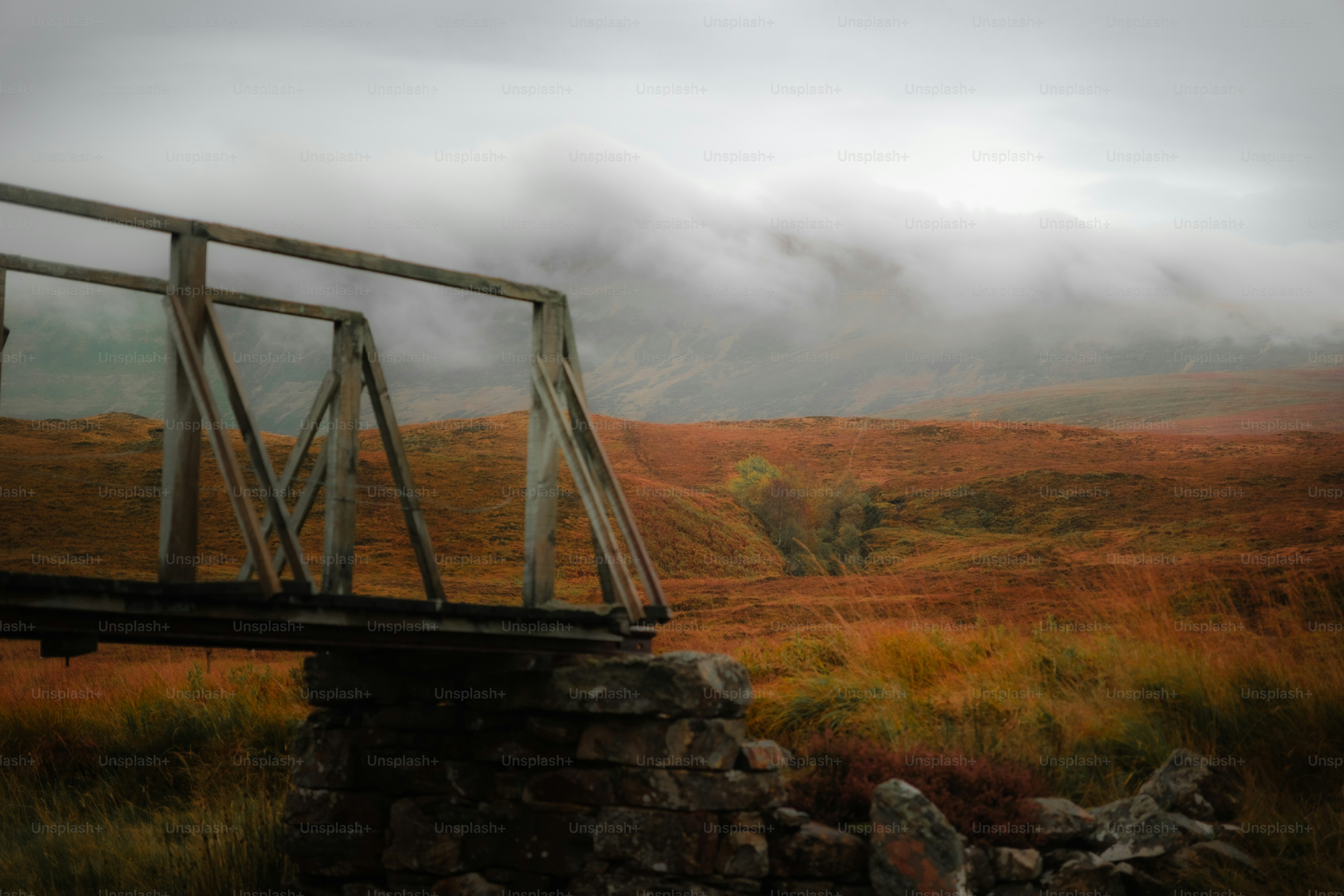 A bridge in the middle of a field on a cloudy day