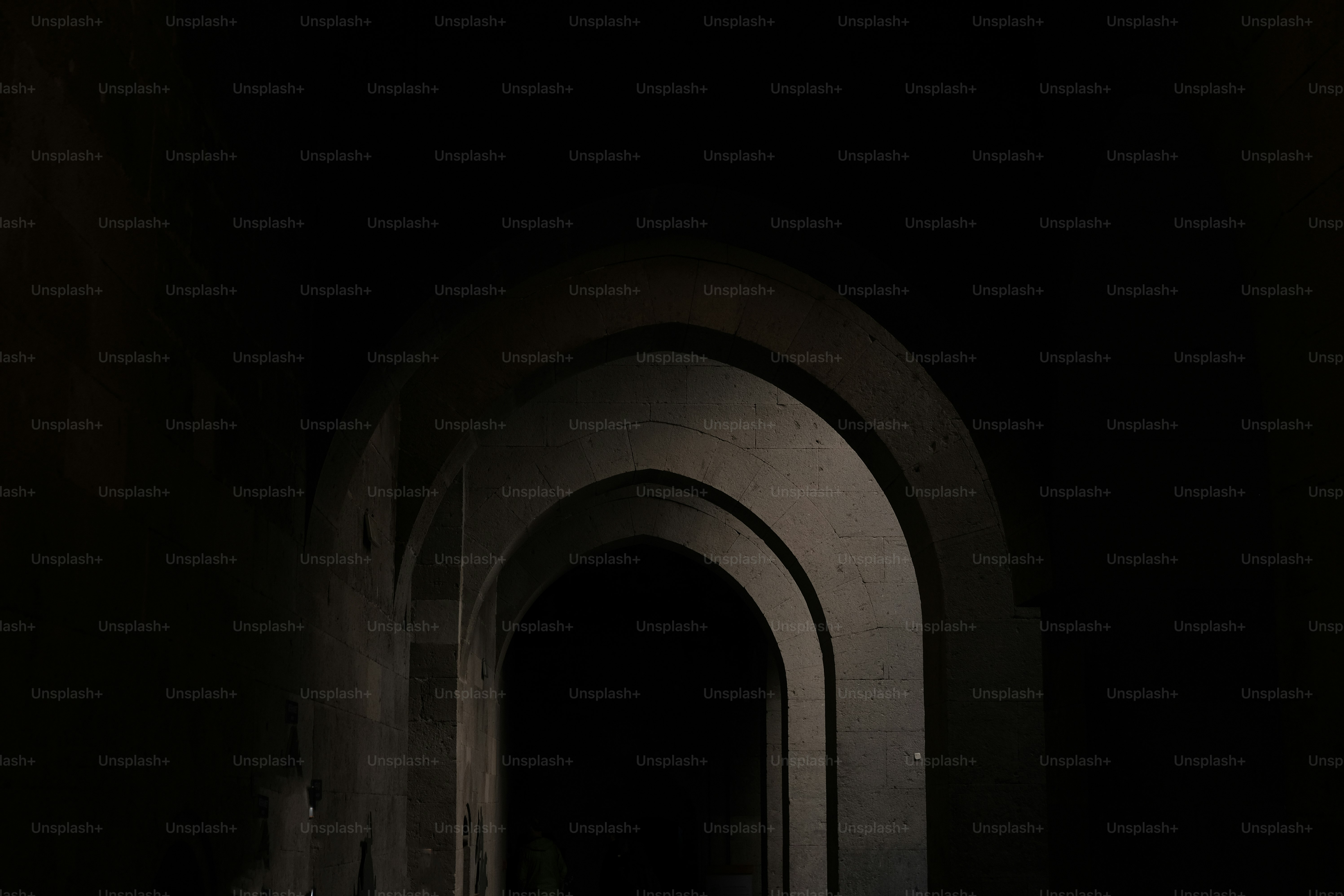 A dark hallway with a light at the end of it