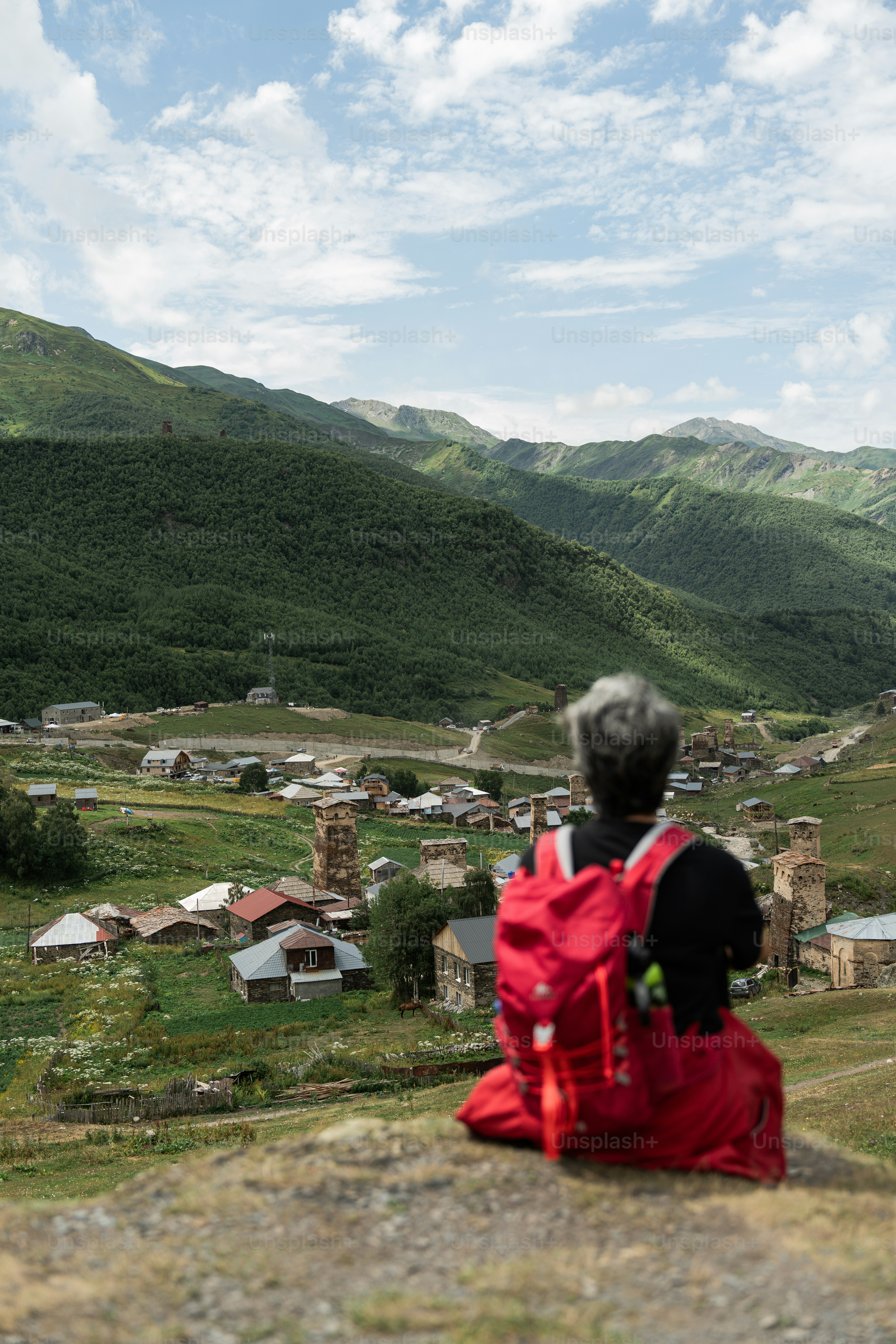A person sitting on a rock looking at a village