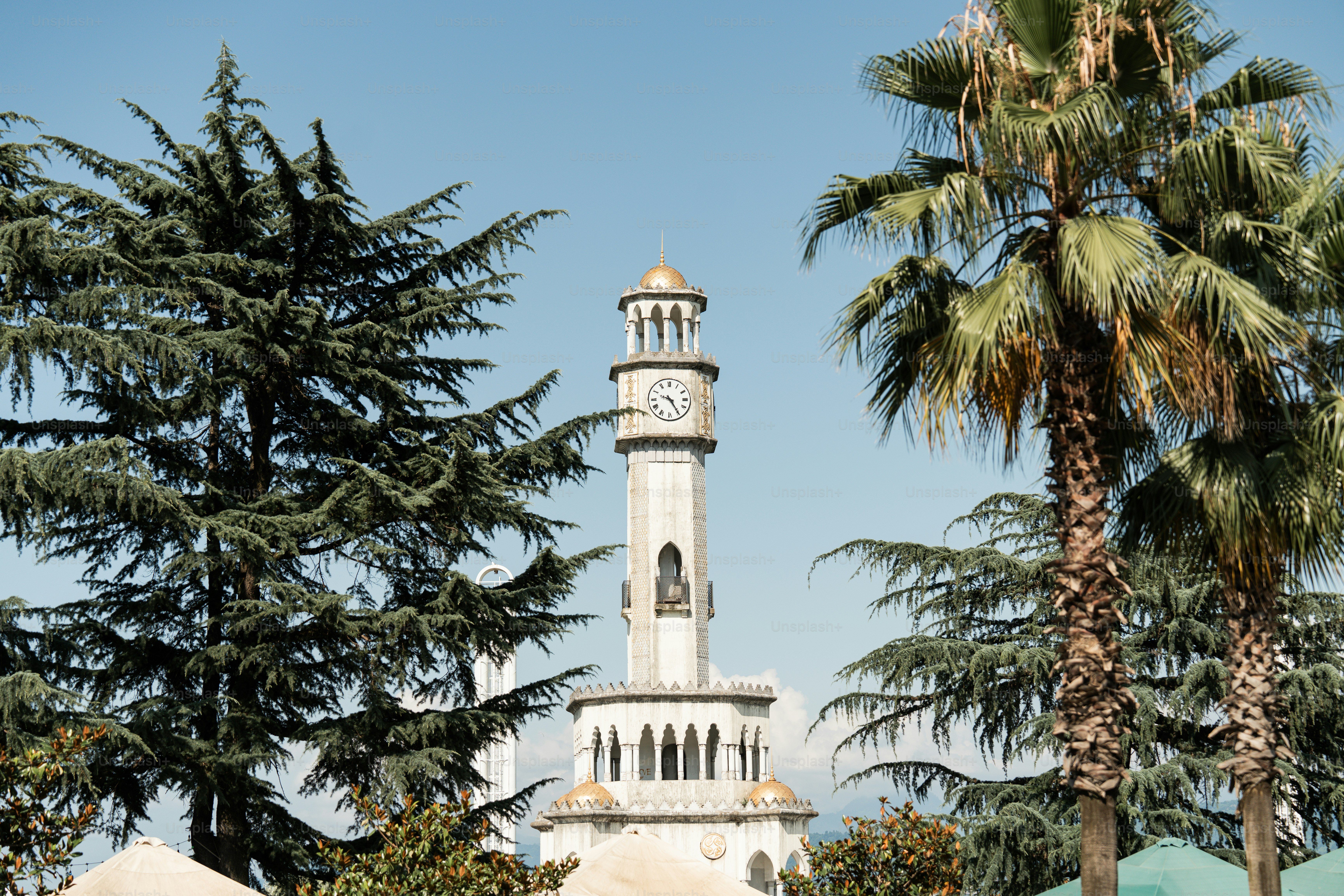 Un grand bâtiment blanc avec une tour d’horloge