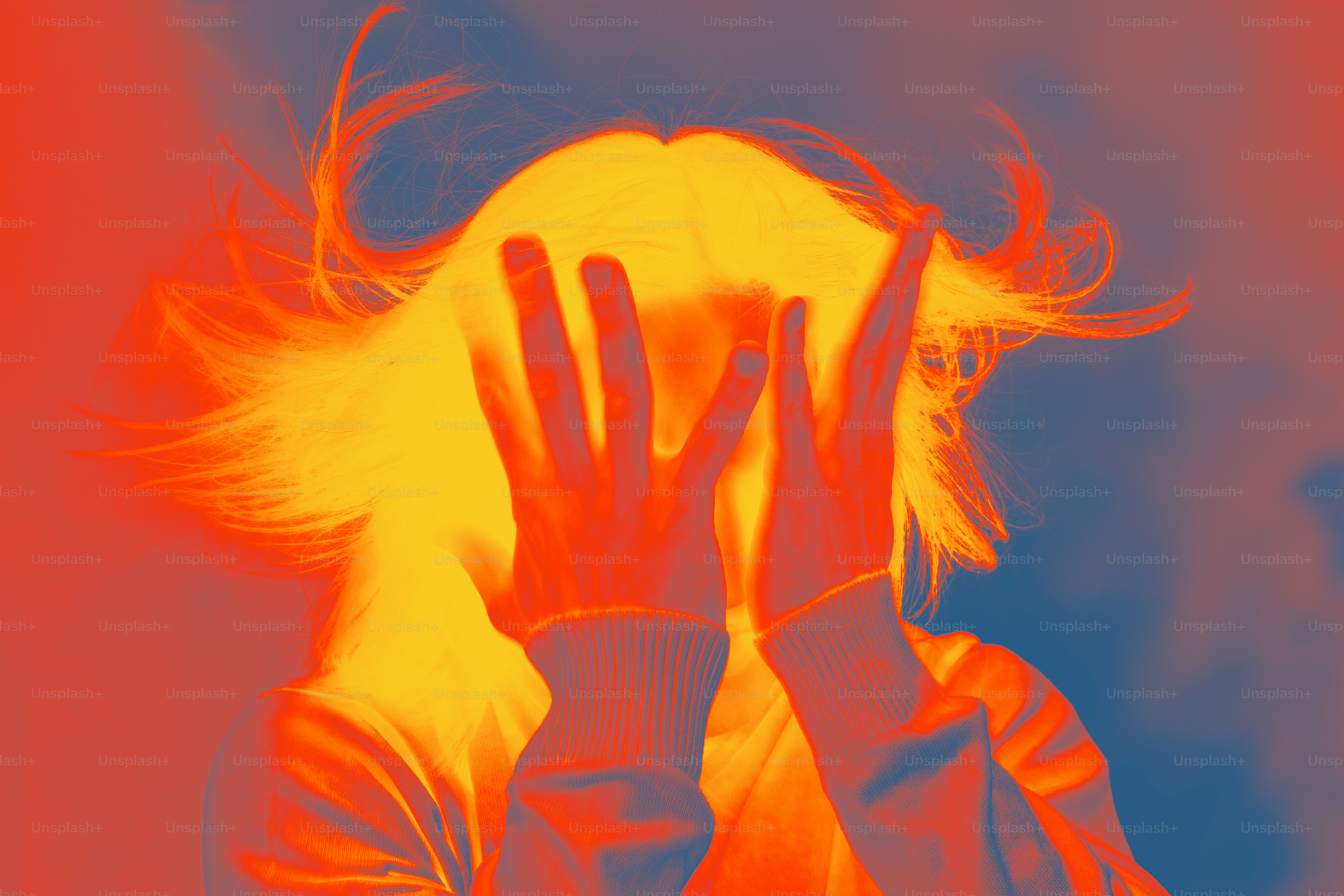 A woman covering her face with her hands