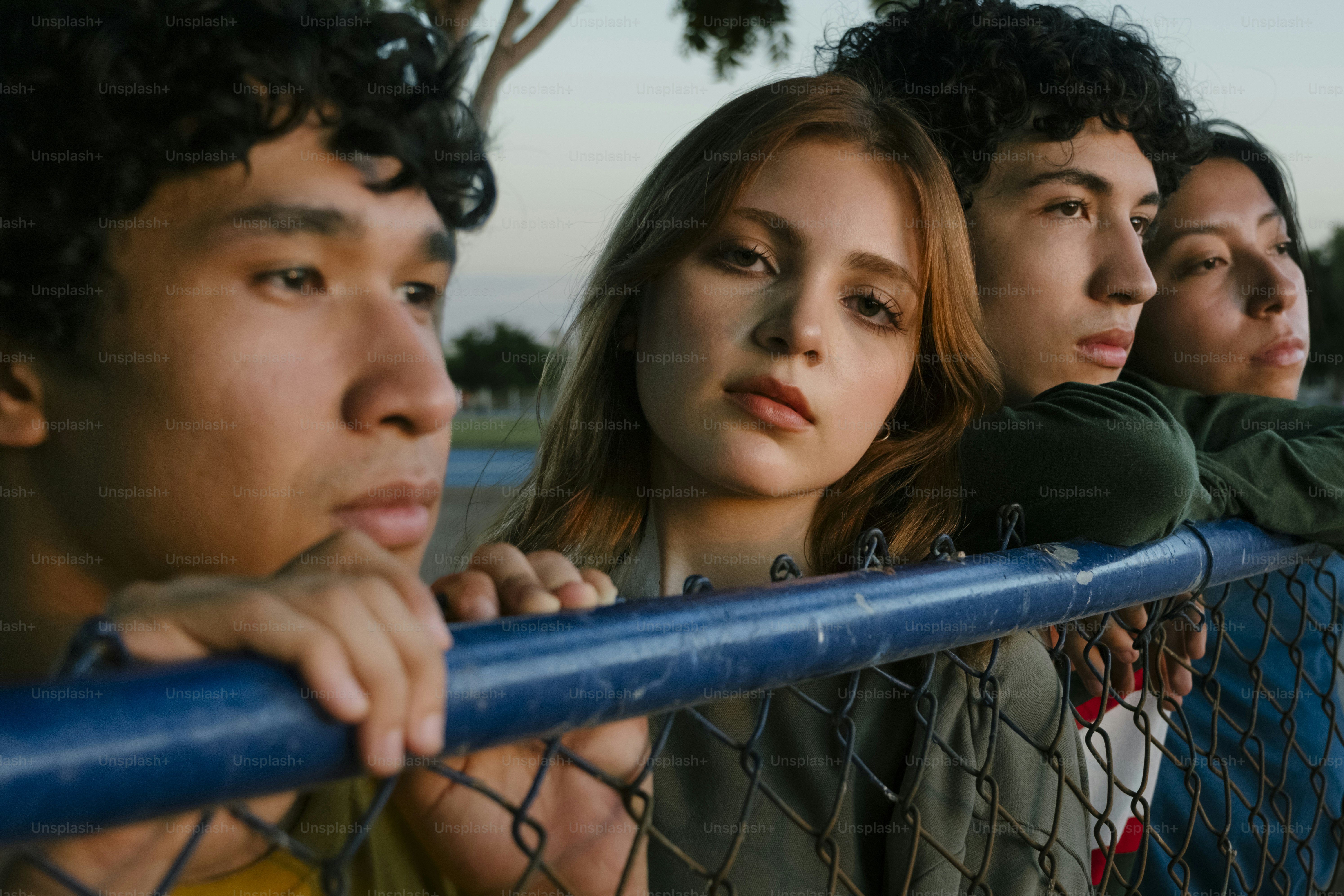 A group of young people standing behind a fence photo – Friendships ...