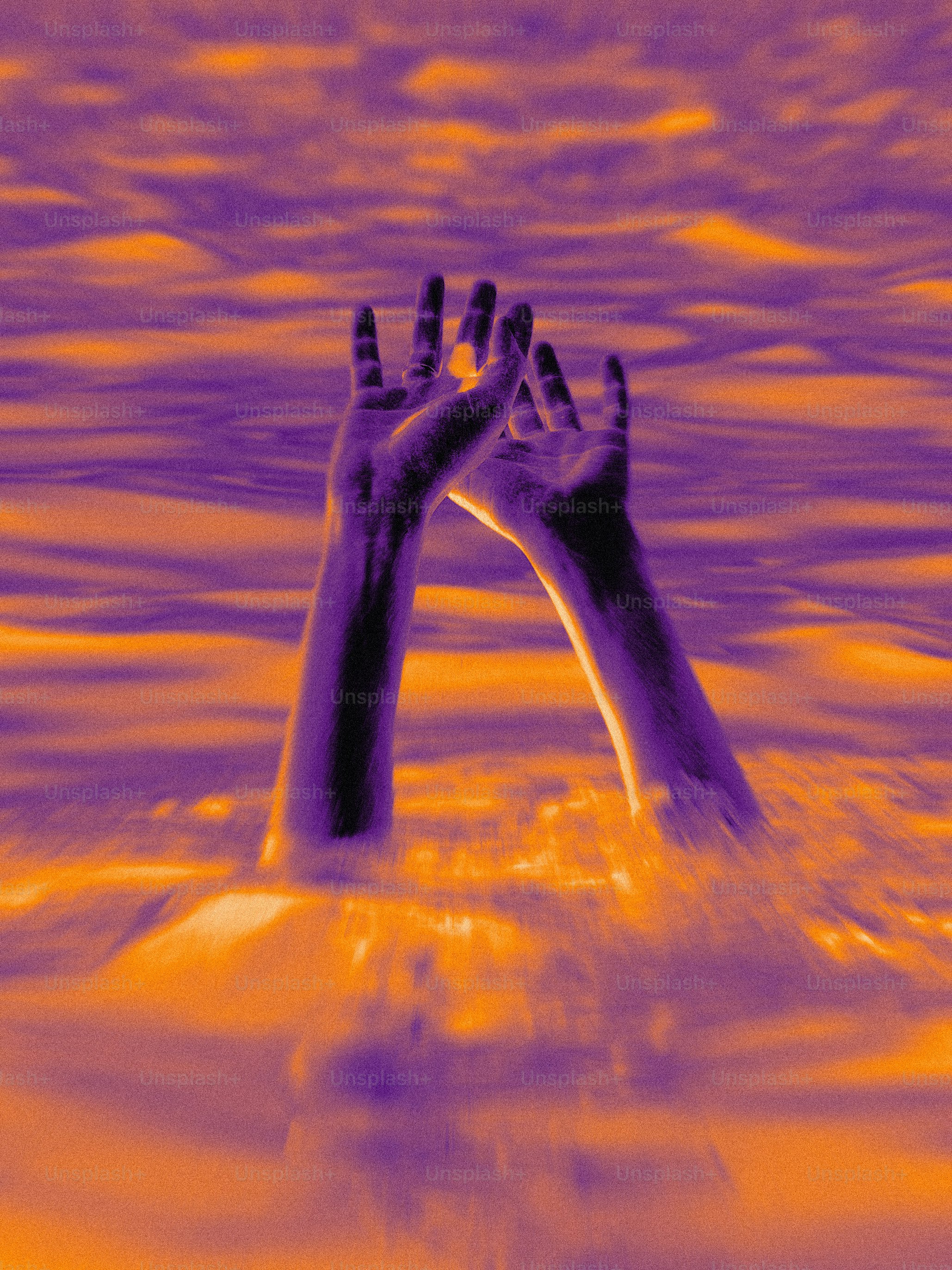 A pair of hands reaching out of the water