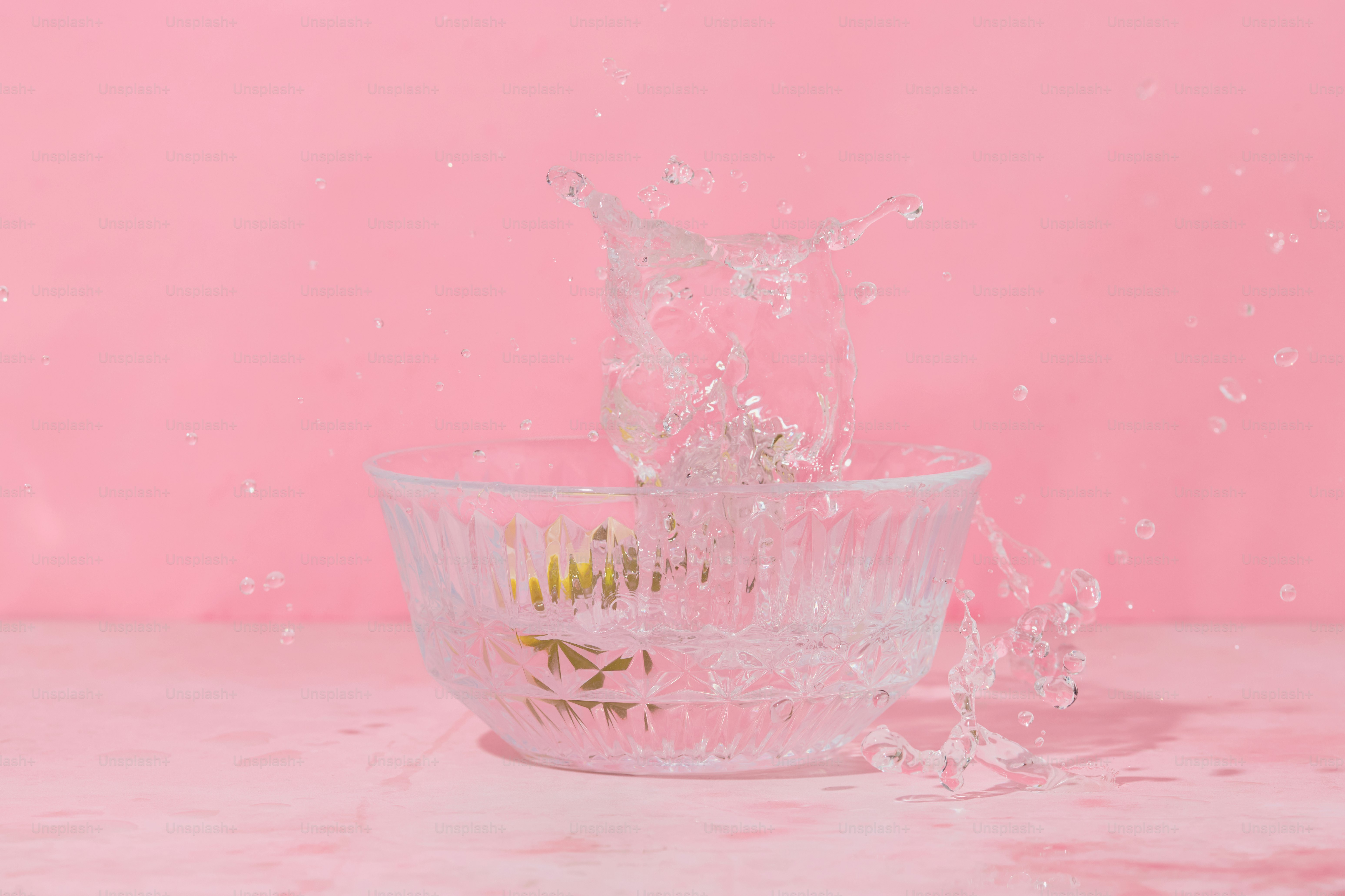 A glass bowl with water splashing out of it
