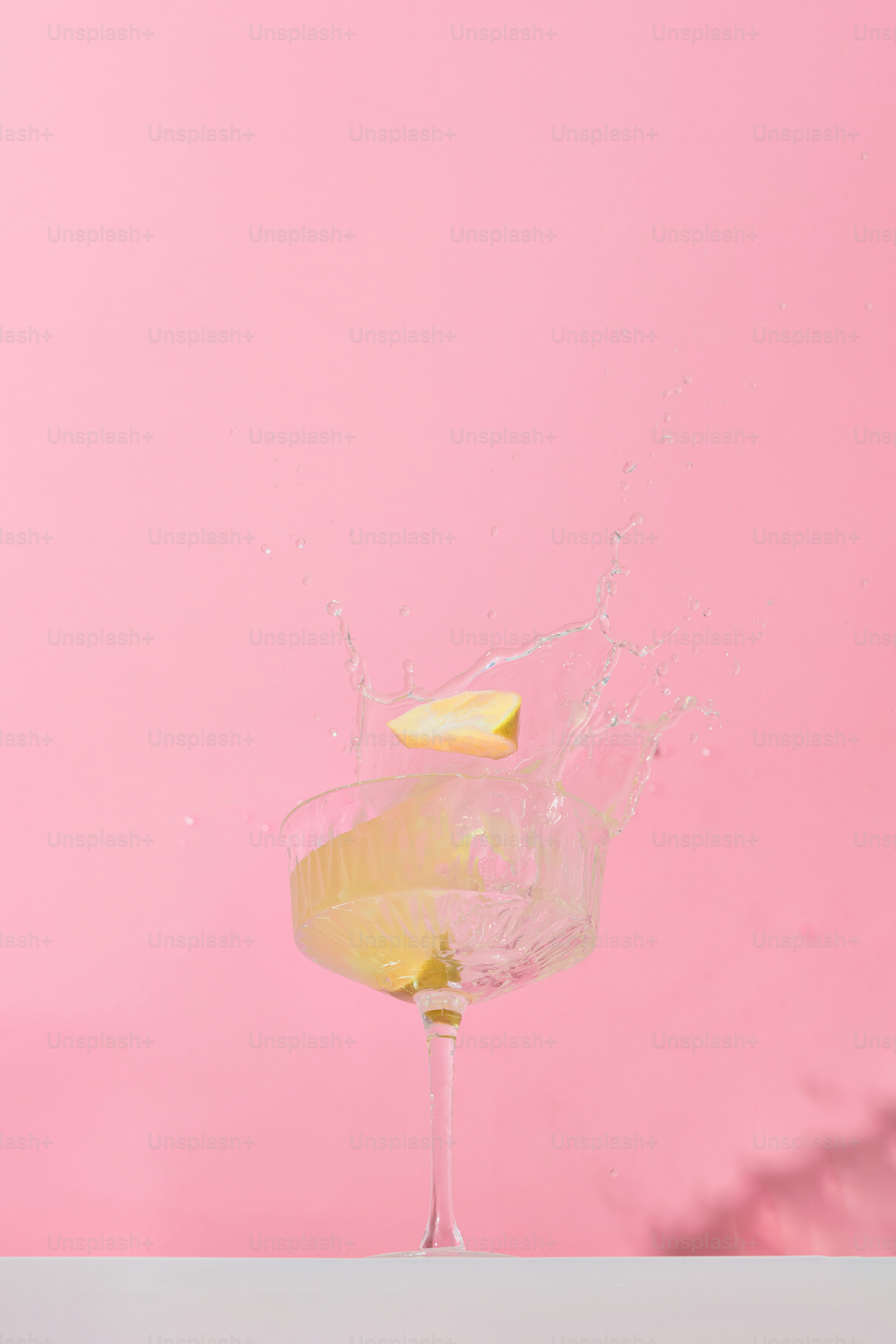 Lemons falling into cocktail glass causing a splash.