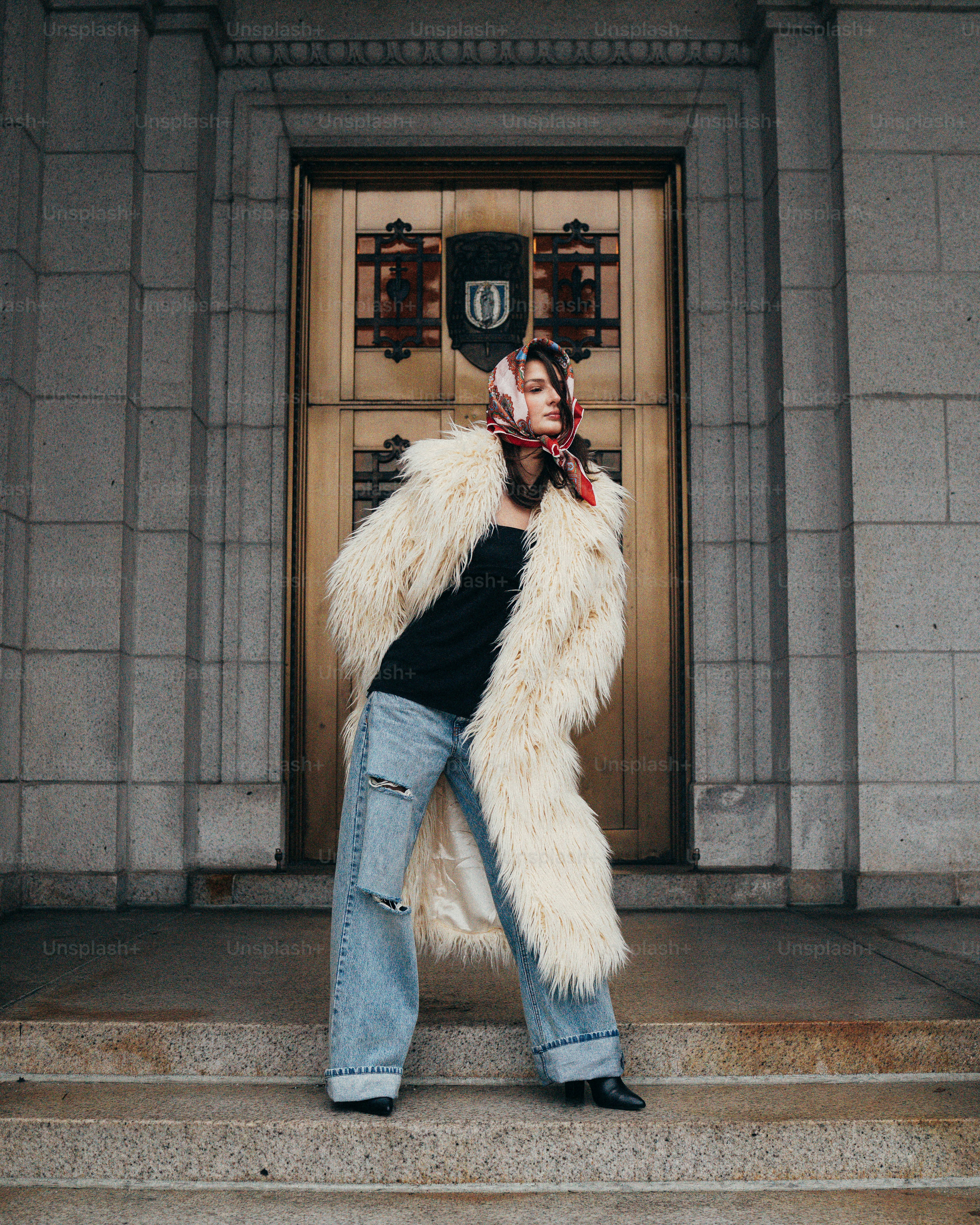 A woman in a fur coat standing on steps