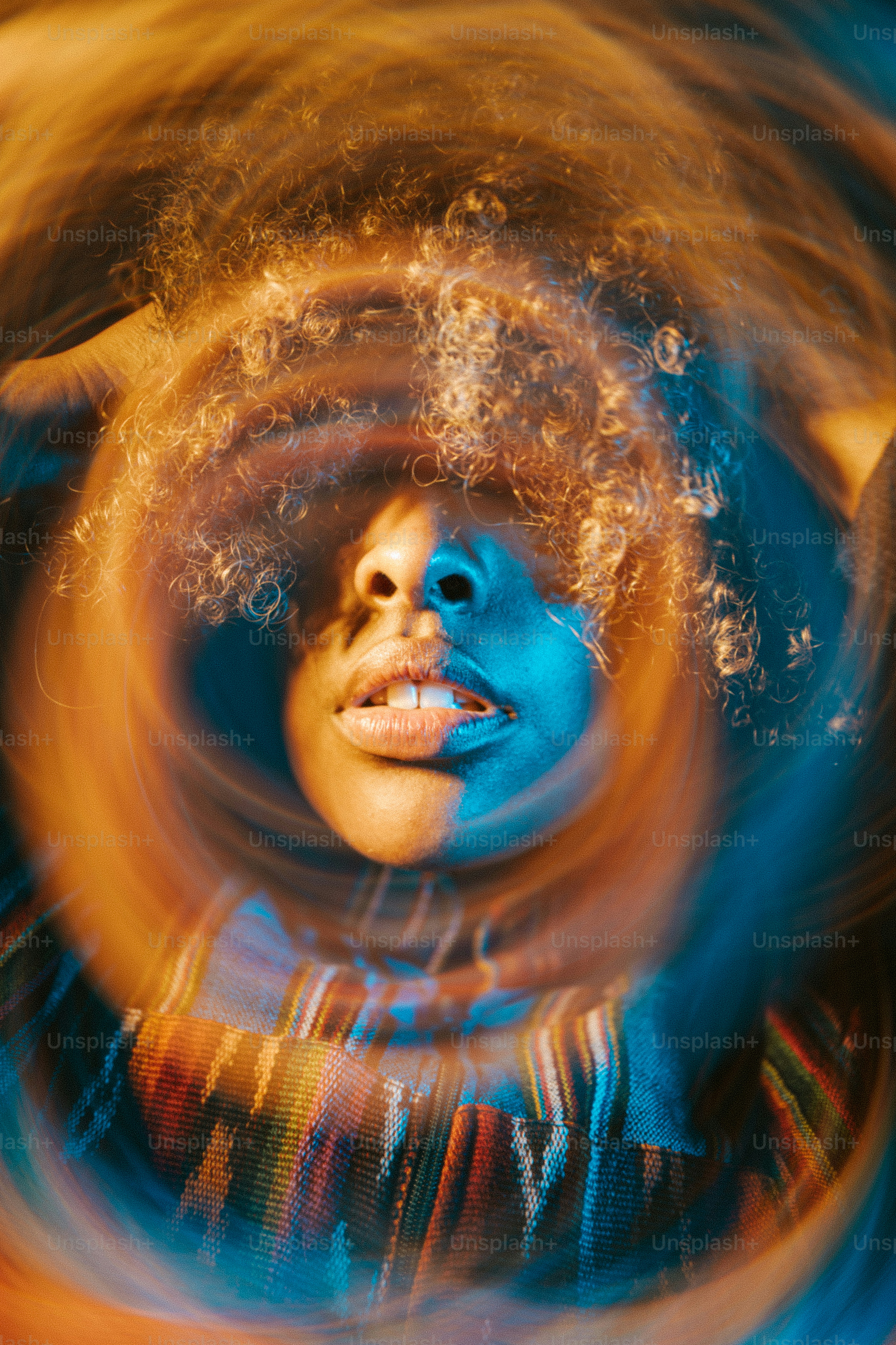 A woman with a blue face is seen through a circular object