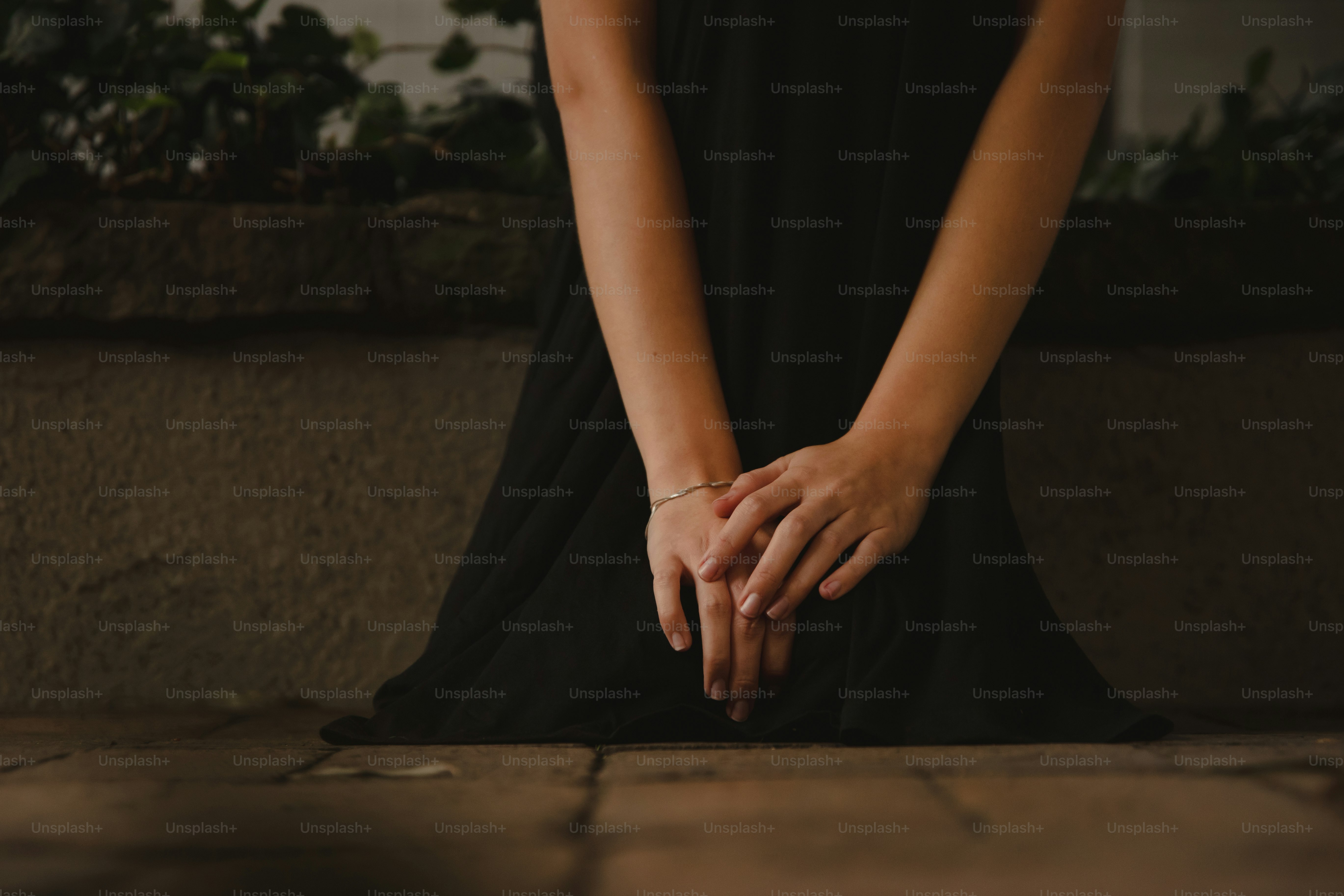 A woman in a black dress sitting on the ground