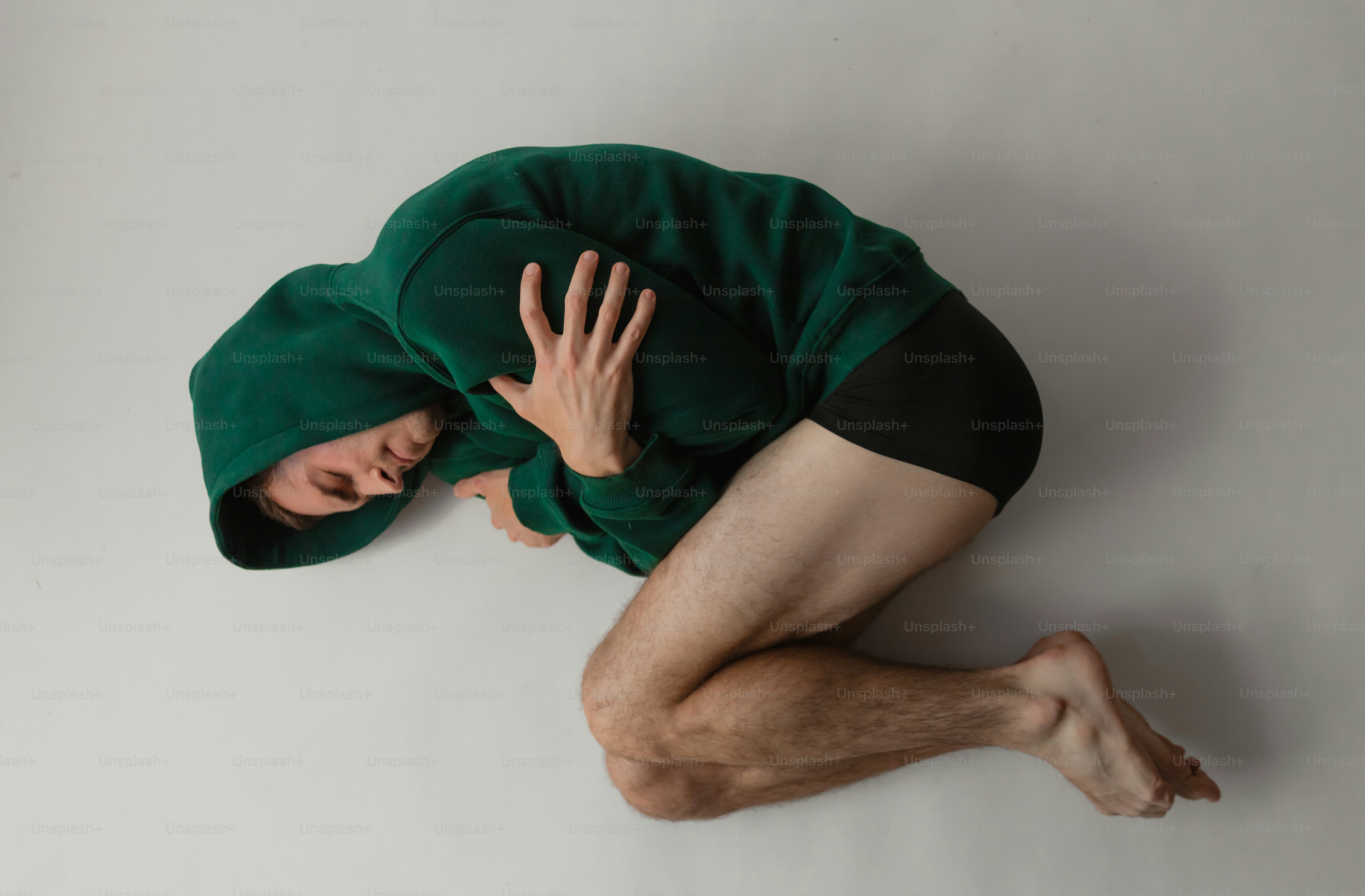 A man in a green shirt laying on the floor